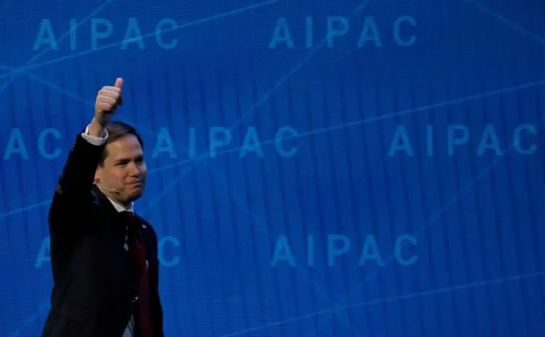 رجل يرفع إبهامه بإيجابية أمام خلفية تحمل شعار AIPAC، في سياق مناقشة تأثير جماعات الضغط على السياسة الأمريكية.