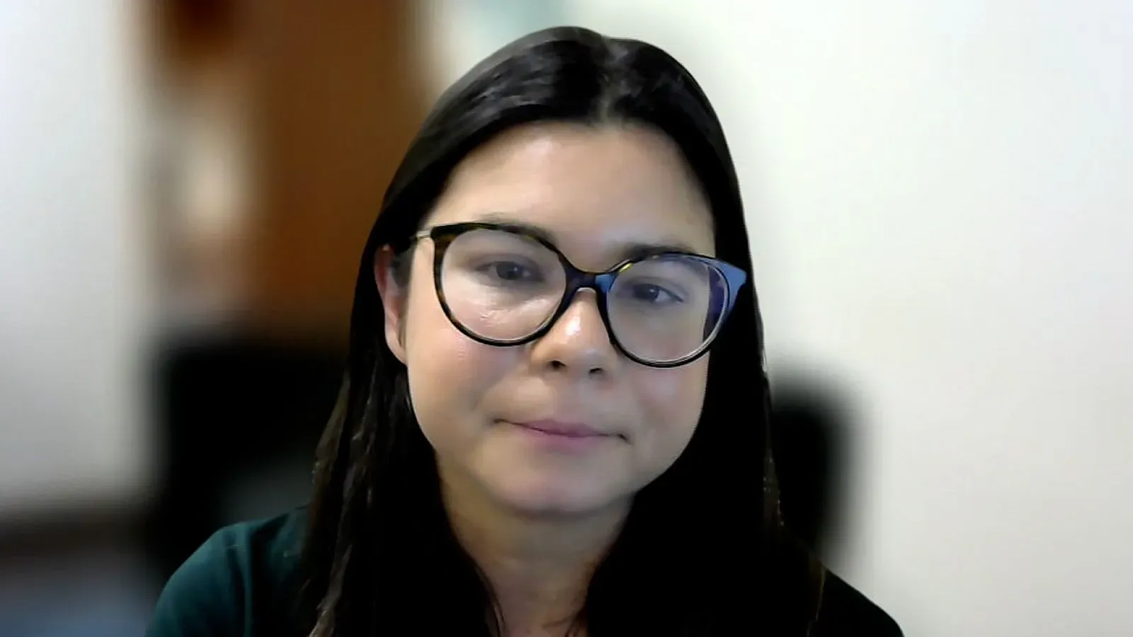 امرأة في الثلاثينيات من عمرها ترتدي نظارات، تعبر عن القلق بشأن ديون القروض الطلابية وتأثيرها على حياتها الأسرية.