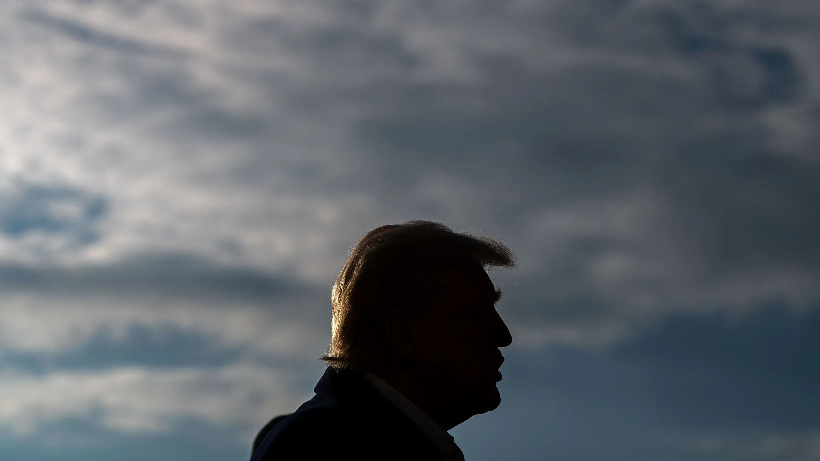 صورة جانبية لترامب مع سماء غائمة خلفه، تعكس حالة التوتر المرتبطة بالرسوم الجمركية الجديدة المرتقبة على كندا.