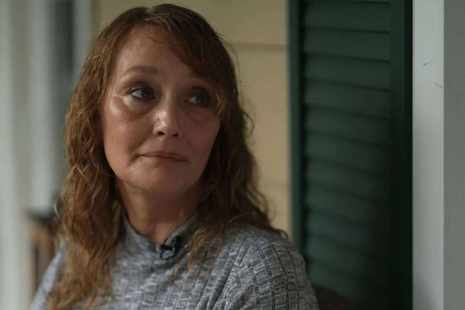 امرأة شابة تعبر عن قلقها بشأن خطر الفيضانات في مستشفى نفسي بالقرب من نهر تينيسي، معبرة عن مشاعر الخوف والقلق.