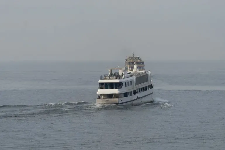 قارب يبحر في نهر ضبابي، يعكس أهمية النقل النهري في جمهورية الكونغو الديمقراطية وسط حوادث مأساوية.