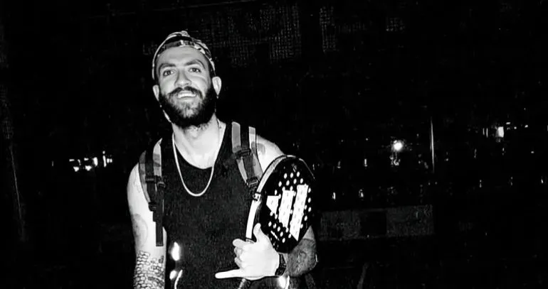 بارسا منصور، لاعب تنس محترف، مبتسم ويظهر مضربه، قبل الهجمات الإسرائيلية التي أدت إلى وفاته في طهران.