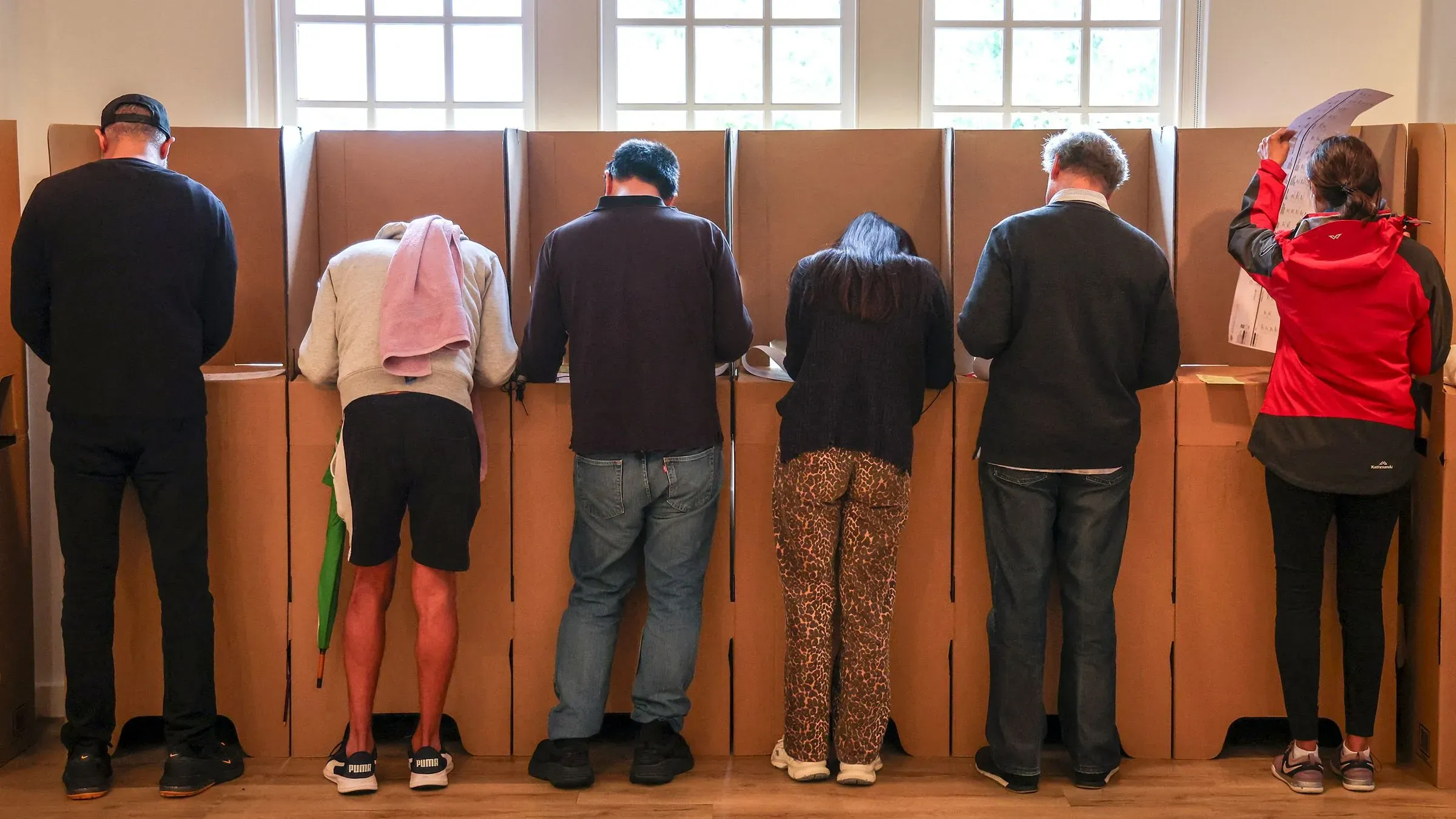 ناخبون يقفون في مراكز الاقتراع خلال الانتخابات الأسترالية، حيث يتفاعل المواطنون مع العملية الديمقراطية وسط مخاوف من غلاء المعيشة.