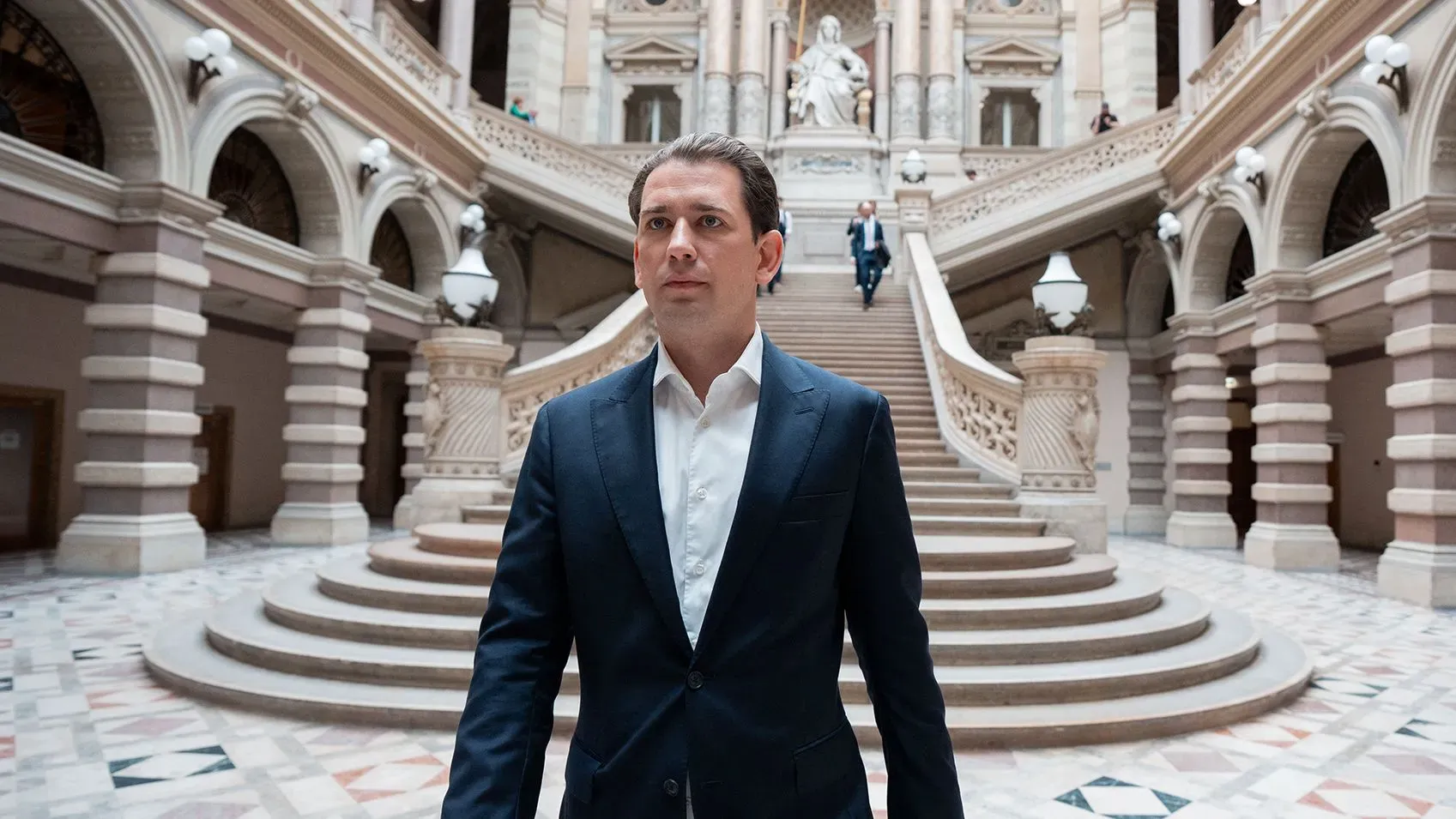 المستشار النمساوي السابق سيباستيان كورتس يسير في مبنى حكومي تاريخي، وسط سلالم وأعمدة معمارية، بعد إلغاء إدانته.