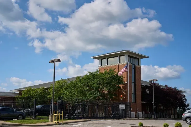 مبنى حكومي في ناشفيل مع علم الولايات المتحدة يرفرف، محاط بأشجار، وسط سماء زرقاء مع غيوم بيضاء، في سياق اعتقالات المهاجرين.