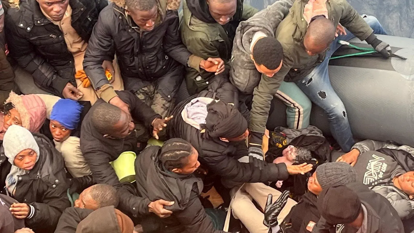 طفلة رضيعة تُولد على متن قارب مهاجرين قبالة سواحل جزر الكناري، وسط مجموعة من المهاجرين في رحلة محفوفة بالمخاطر.