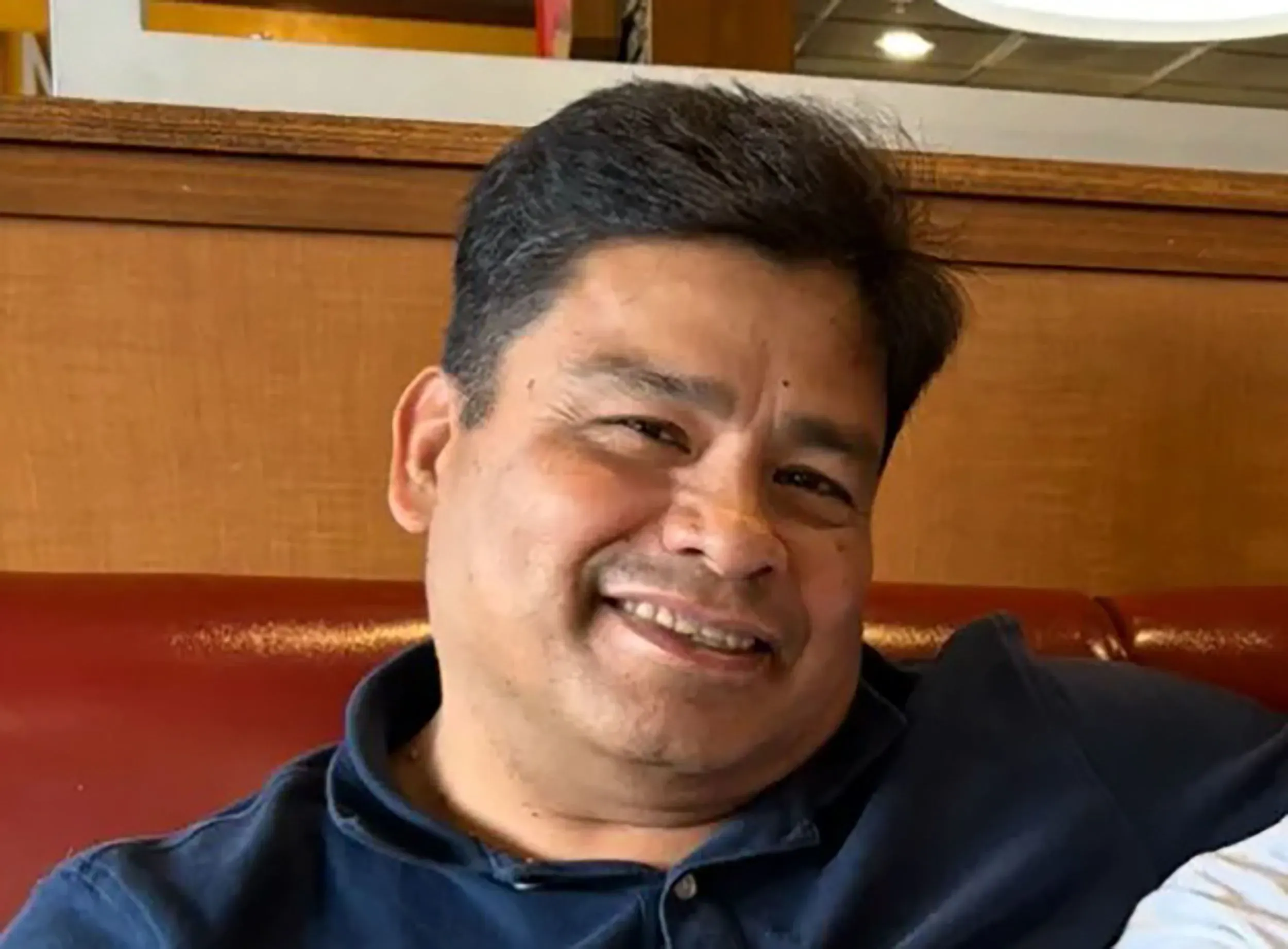 صورة لرجل مبتسم يجلس في مطعم، يعكس لحظة من السعادة. يظهر في سياق حادث إطلاق نار مأساوي في رينو بولاية نيفادا.