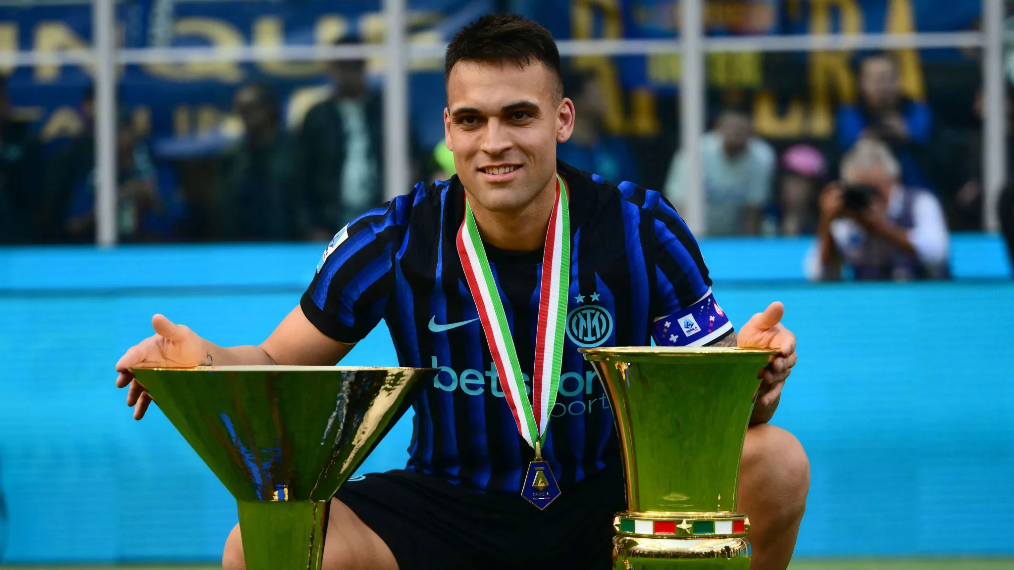 لاعب كرة القدم أشرف حكيمي يرتدي زي إنتر ميلان ويحمل كأس الدوري الإيطالي وكأس السوبر الإيطالي مع ميدالية حول عنقه، معززاً مكانته كمرشح قوي للكرة الذهبية 2026.