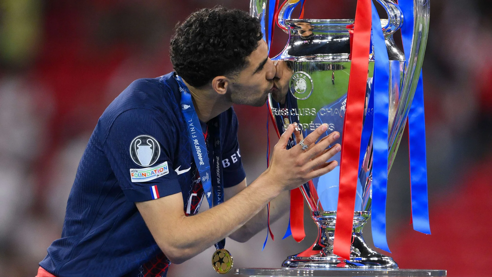 أشرف حكيمي يقبل كأس دوري أبطال أوروبا بعد تتويجه مع باريس سان جيرمان في موسم 2025-26، مرشح قوي للكرة الذهبية 2026.