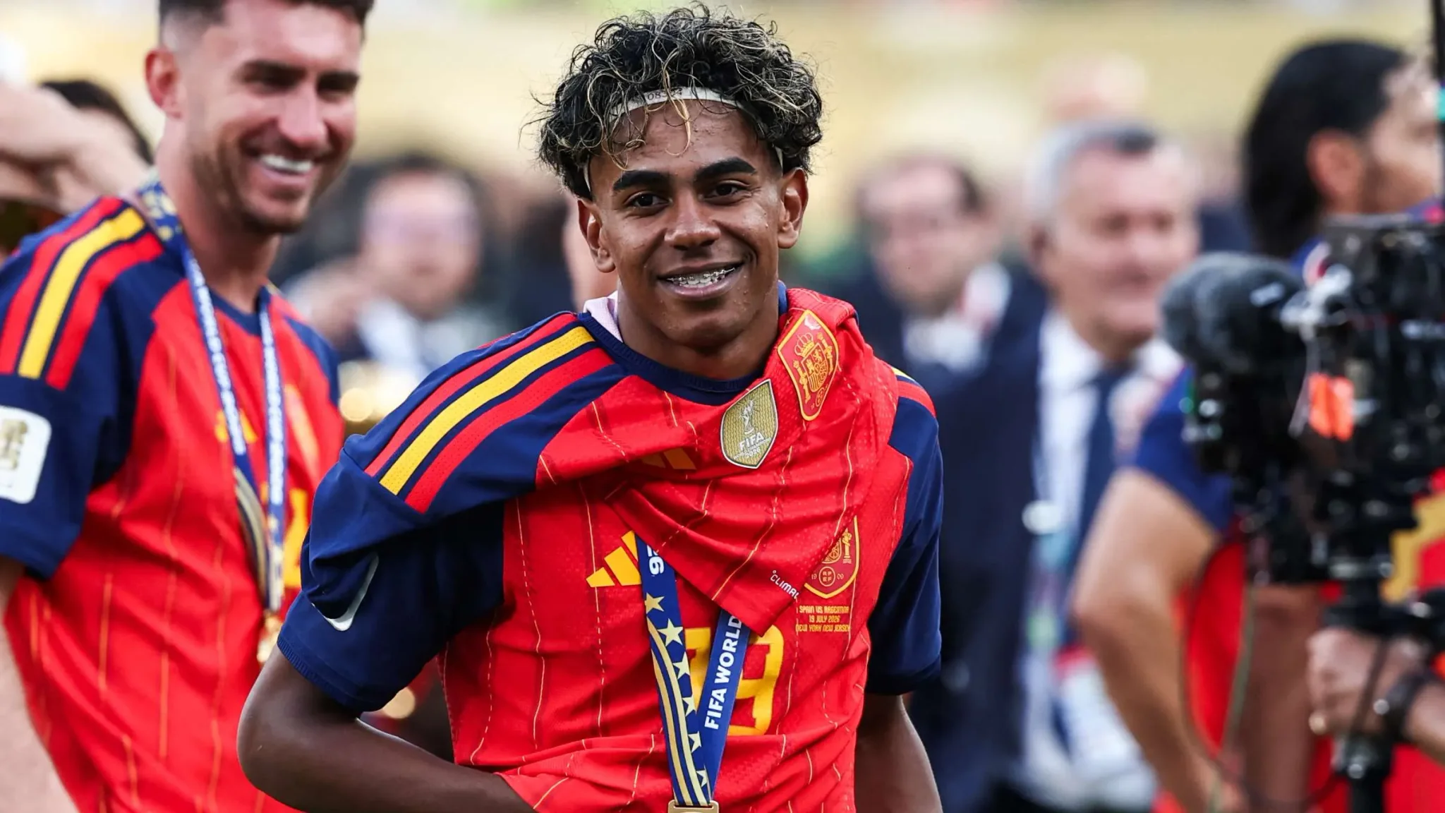 لاعب كرة قدم إسباني شاب يحتفل بفوز منتخب إسبانيا بكأس العالم 2026 مرتدياً قميص المنتخب وميدالية البطولة.