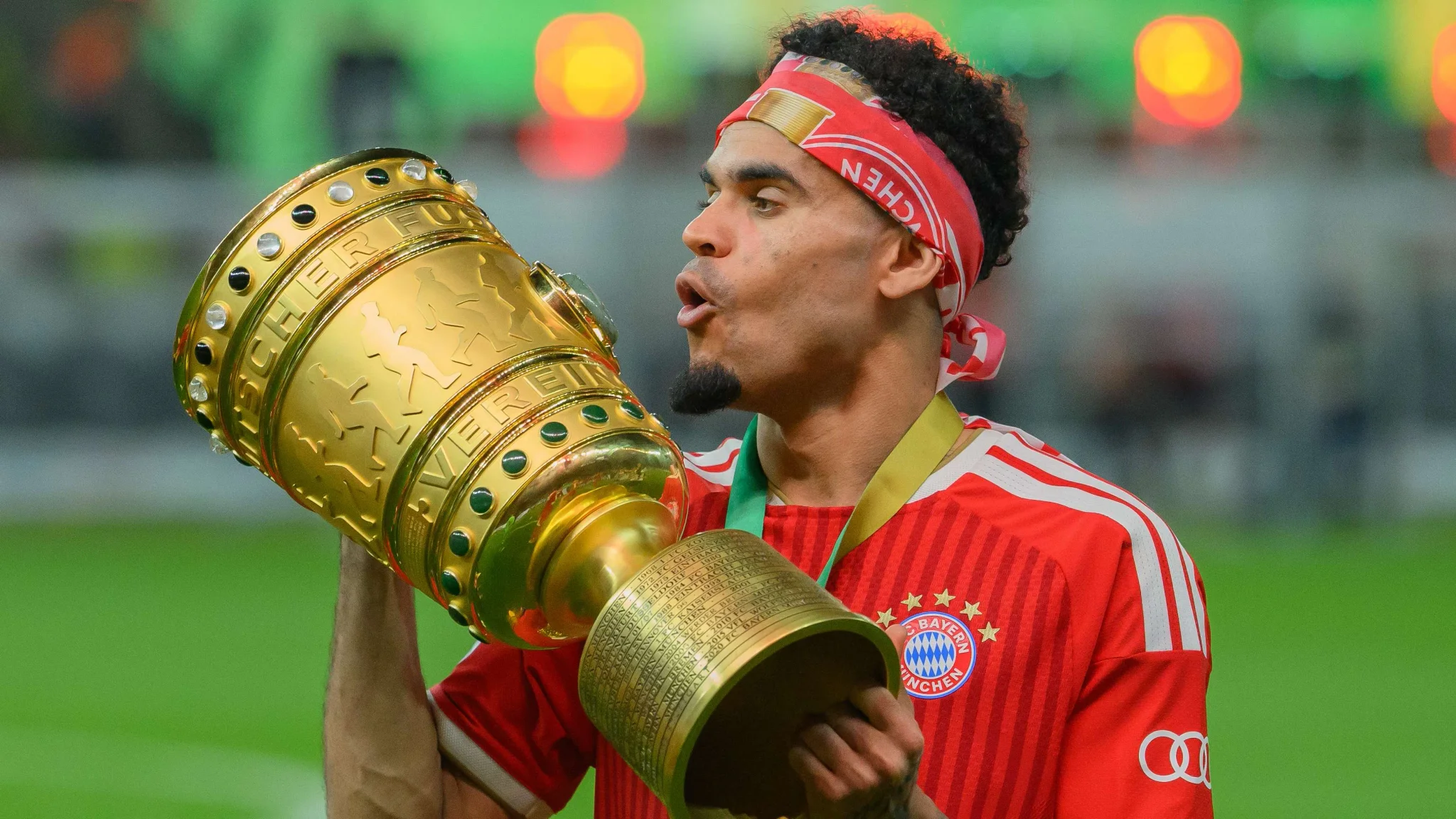 لاعب بايرن ميونخ يحتفل بتتويجه بكأس ألمانيا، مع التركيز على إنجازاته في موسم 2025-26 وتألقه في سباق الكرة الذهبية.