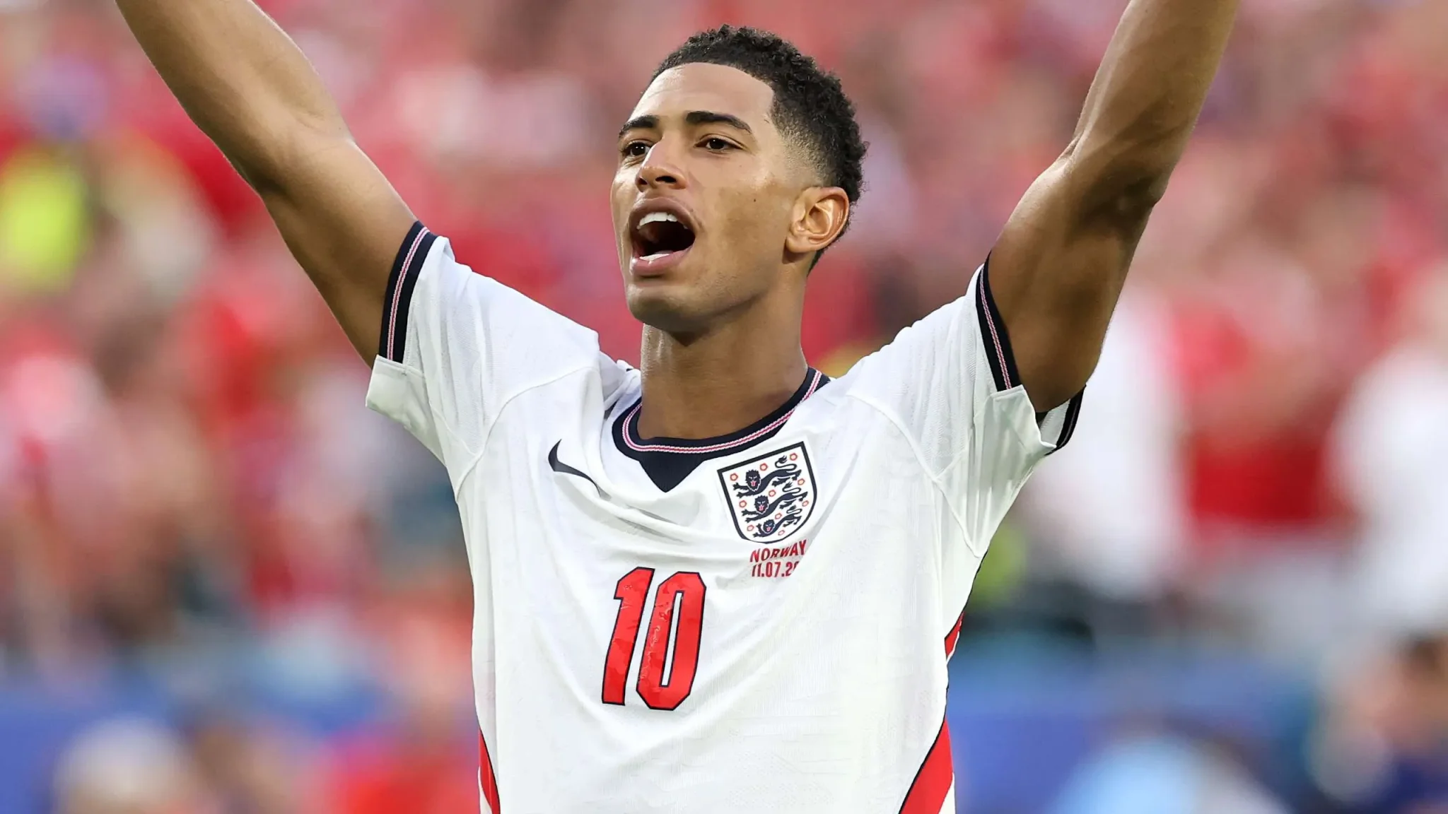 لاعب كرة قدم إنجليزي يرتدي قميص منتخب إنجلترا رقم 10 يرفع ذراعيه في احتفال خلال مباراة دولية.