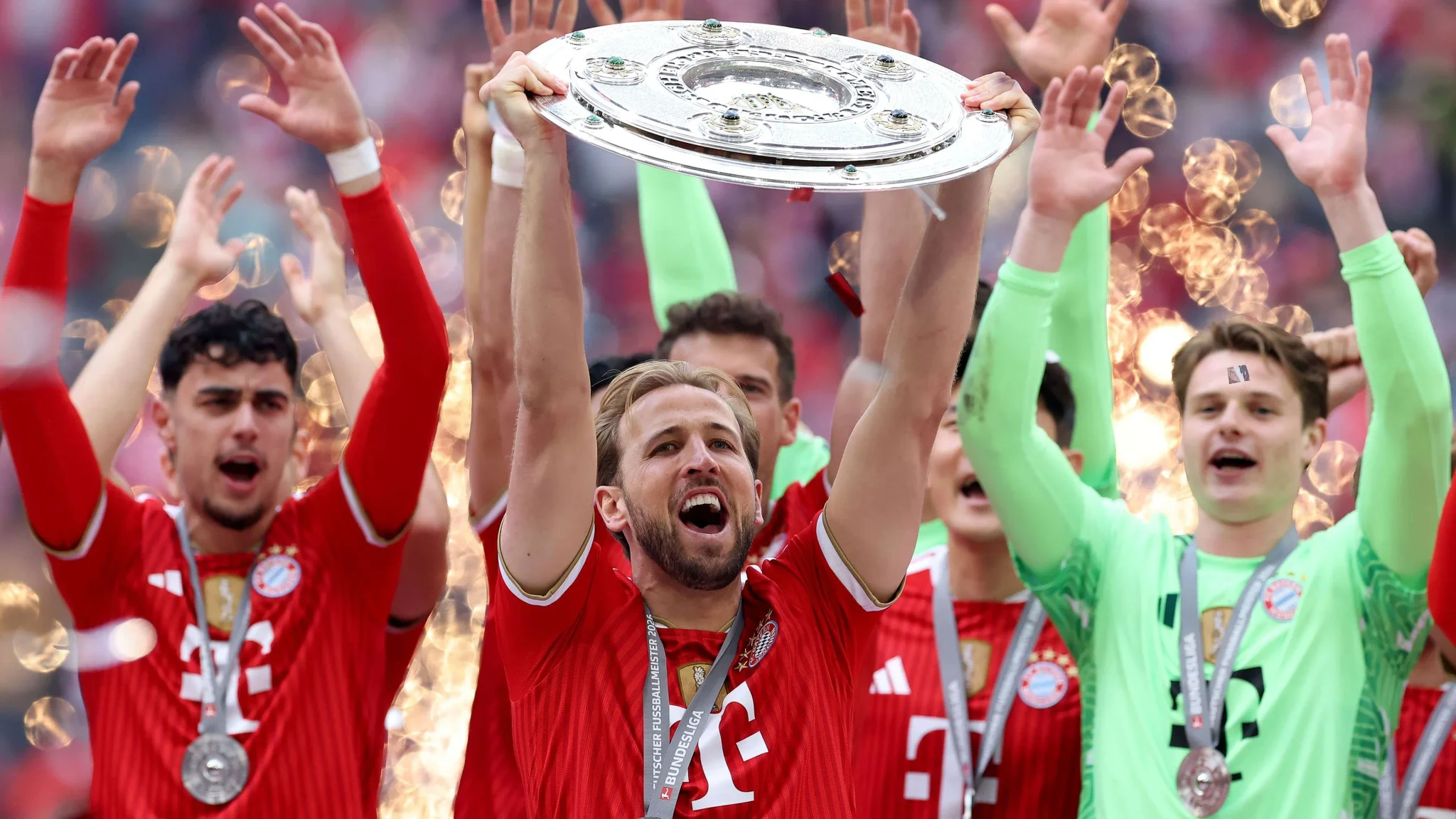 لاعبو بايرن ميونخ يحتفلون بحمل درع الدوري الألماني وسط أجواء احتفالية في ملعب أليانز أرينا.