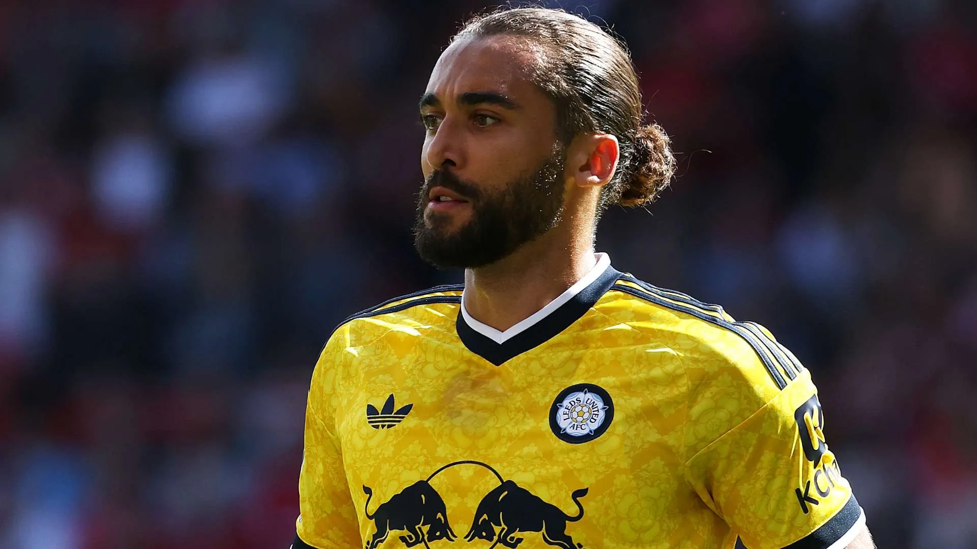 لاعب ليدز يونايتد دومينيك كالفرت-ليوين يرتدي قميص الفريق الأصفر خلال مباراة الدوري الإنجليزي الممتاز، مع تركيز على أدائه وتحمله الضربات.