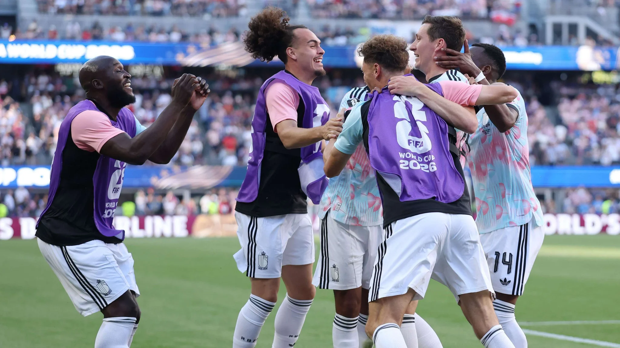 لاعبو منتخب إسبانيا يحتفلون معاً في ملعب لوس أنجلوس قبل مواجهة ربع نهائي كأس العالم ضد بلجيكا، مع التركيز على الوحدة والتكتيك الجماعي.