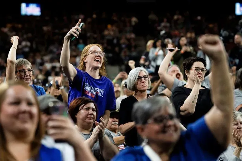 حشد من مؤيدي بيرني ساندرز في تجمع حماسي، يرفعون أيديهم ويظهرون حماسهم خلال الفعالية، مع التركيز على قضايا العدالة الاجتماعية.