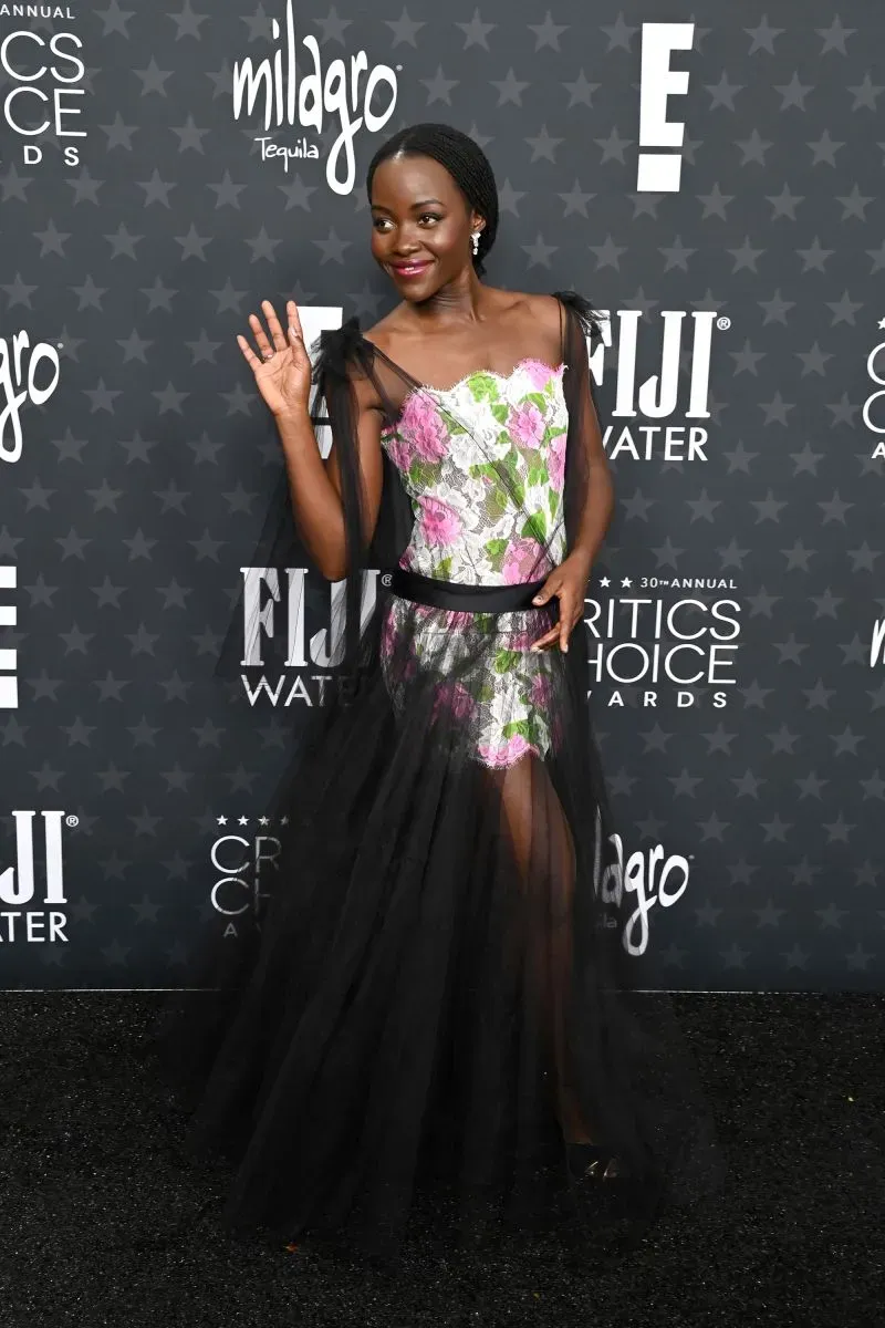 لوك أنيق للممثلة لوبيتا نيونغو في حفل توزيع جوائز اختيار النقاد، ترتدي فستانًا مزينًا بالأزهار مع تفاصيل من الشيفون الأسود.