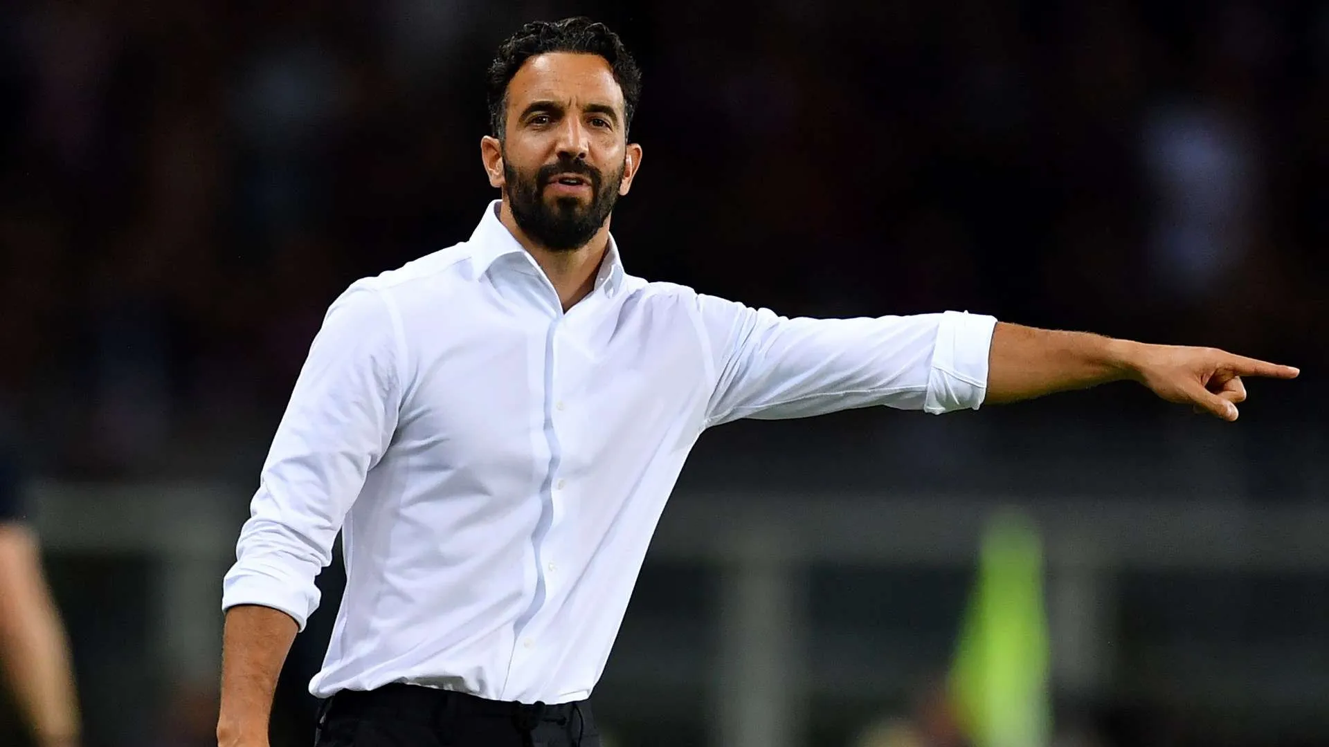 مدرب ميلان Amorim يرتدي قميصًا أبيض ويشير بيده خلال مباراة في الدوري الإيطالي، مع تركيز على استراتيجيته بعد رحيل مهاجمين.