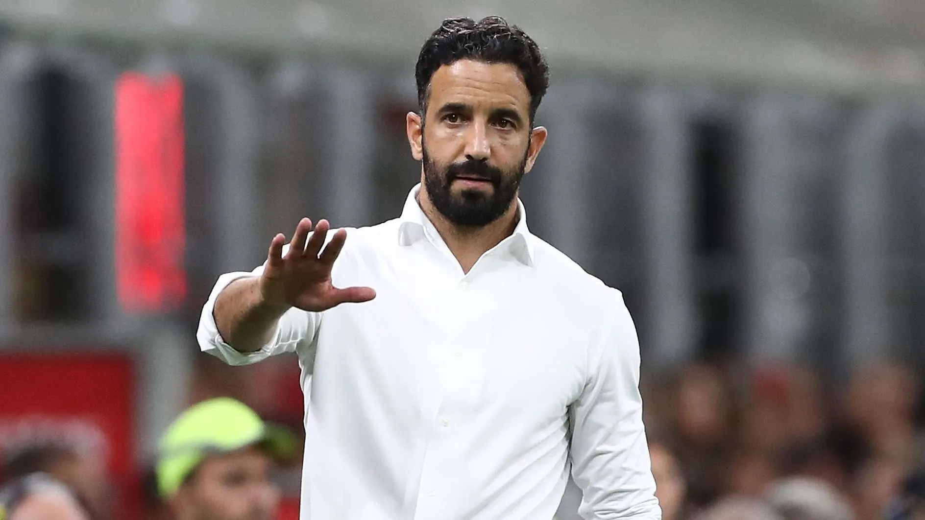المدرب Amorim يرتدي قميصًا أبيض ويشير بيده خلال مباراة في الدوري الإيطالي، مع تركيز على تحضير فريق ميلان لمواجهة يوفنتوس.