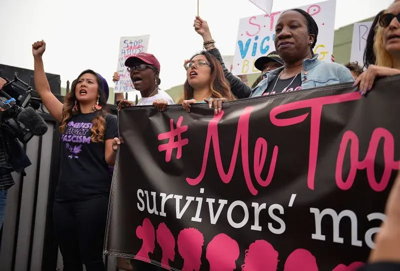 محتجون يحملون لافتة "أنا أيضًا" خلال مسيرة لدعم الناجيات من الاعتداءات الجنسية، مع التركيز على أهمية الحركة في تحقيق العدالة.