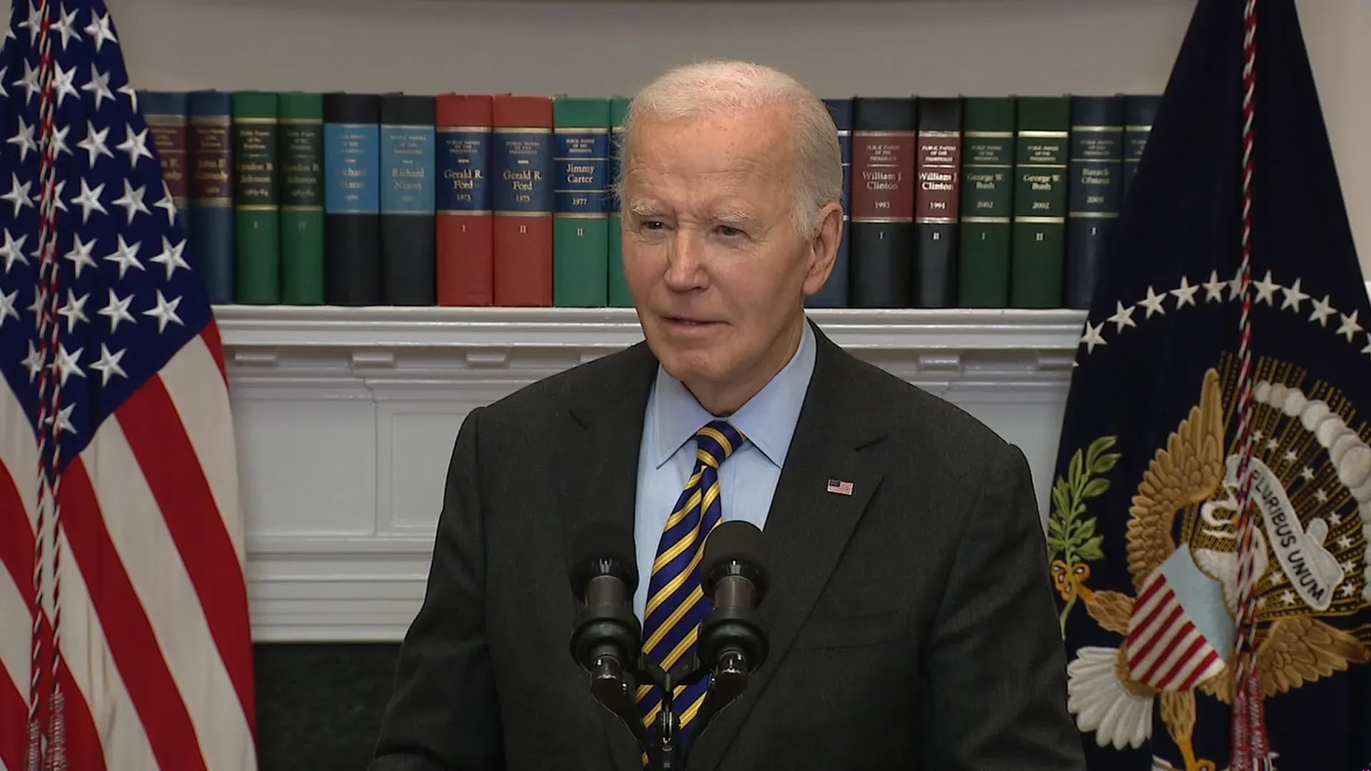 بايدن يتحدث في قاعة روزفلت، مع العلم الأمريكي خلفه، مُشيرًا إلى قضايا مثل الاقتصاد وقرارات ميتا بشأن التحقق من الحقائق.