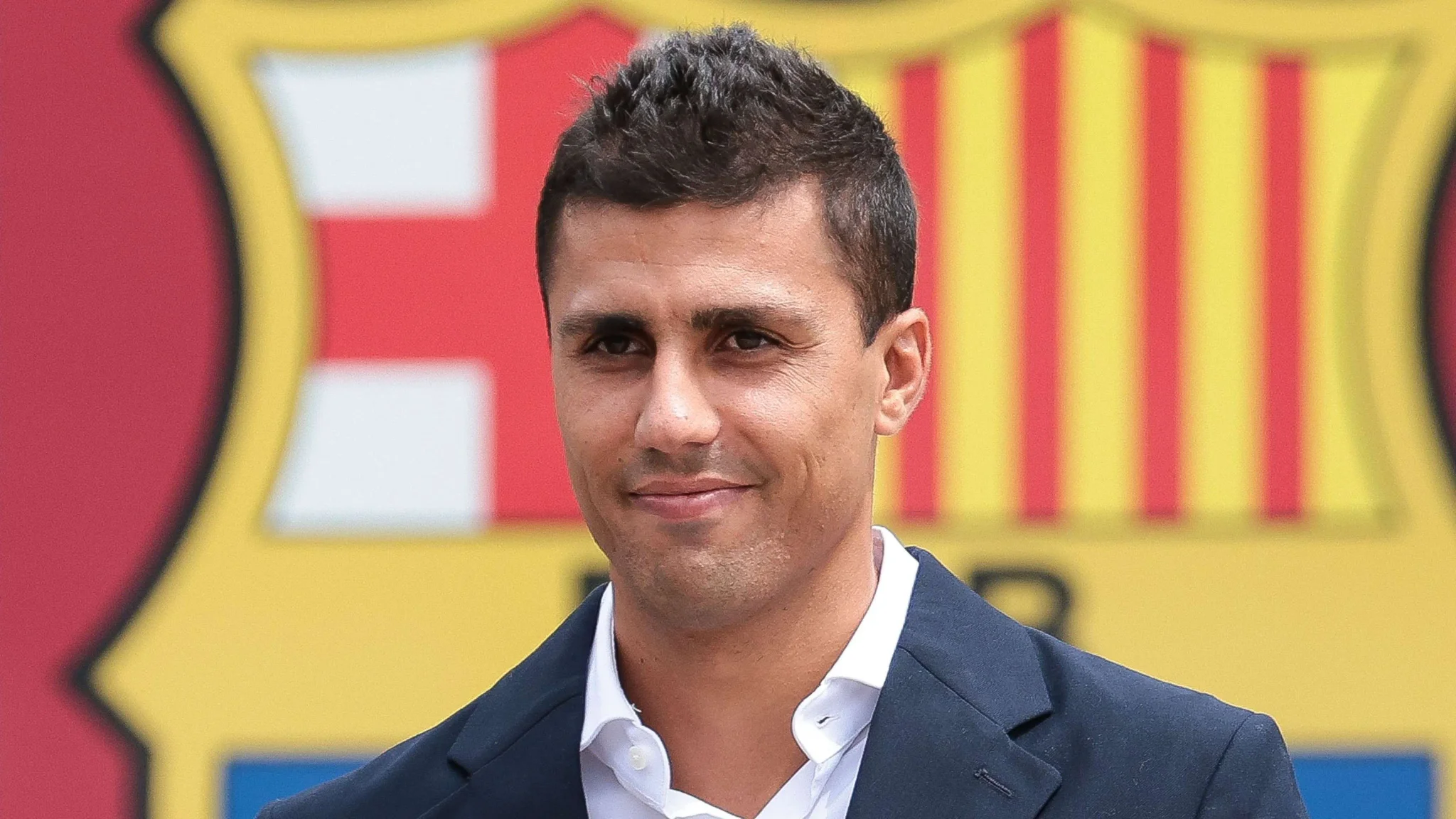 رودري في حفل تقديمه كلاعب وسط جديد لبرشلونة، مع شعار النادي خلفه، بعد انتقاله من مانشستر سيتي في صفقة قياسية.