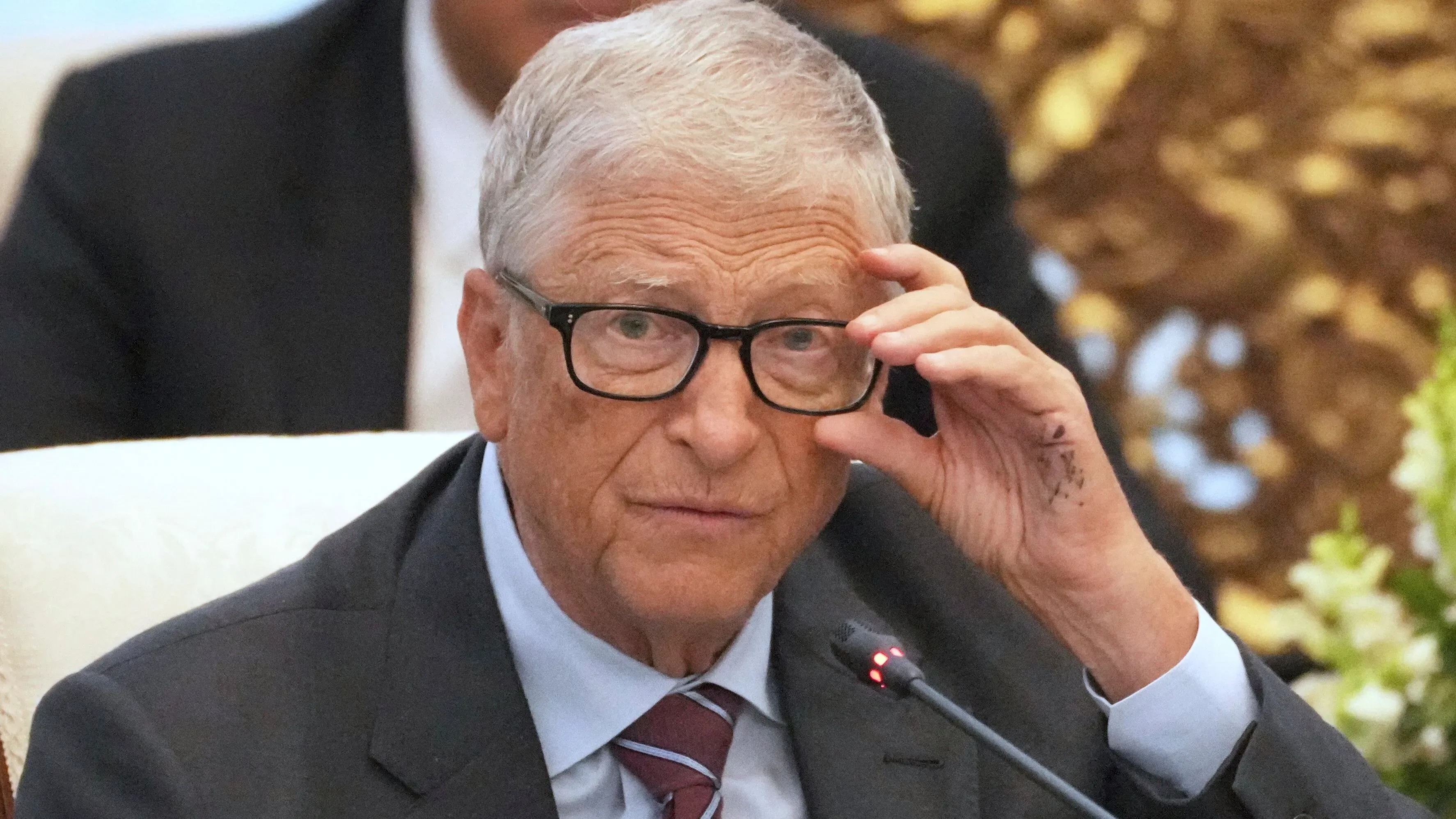 بيل غيتس يتحدث في مؤتمر، مع التركيز على مبادراته الخيرية، حيث يخطط لتوزيع ثروته لدعم الصحة العالمية ومكافحة الفقر.