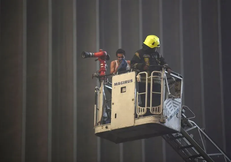 رجال الإطفاء يستخدمون سلة الرفع لإخماد حريق في مركز بيانات بالقاهرة، حيث أسفر الحادث عن وفاة أربعة عمال وإصابة 22 آخرين.