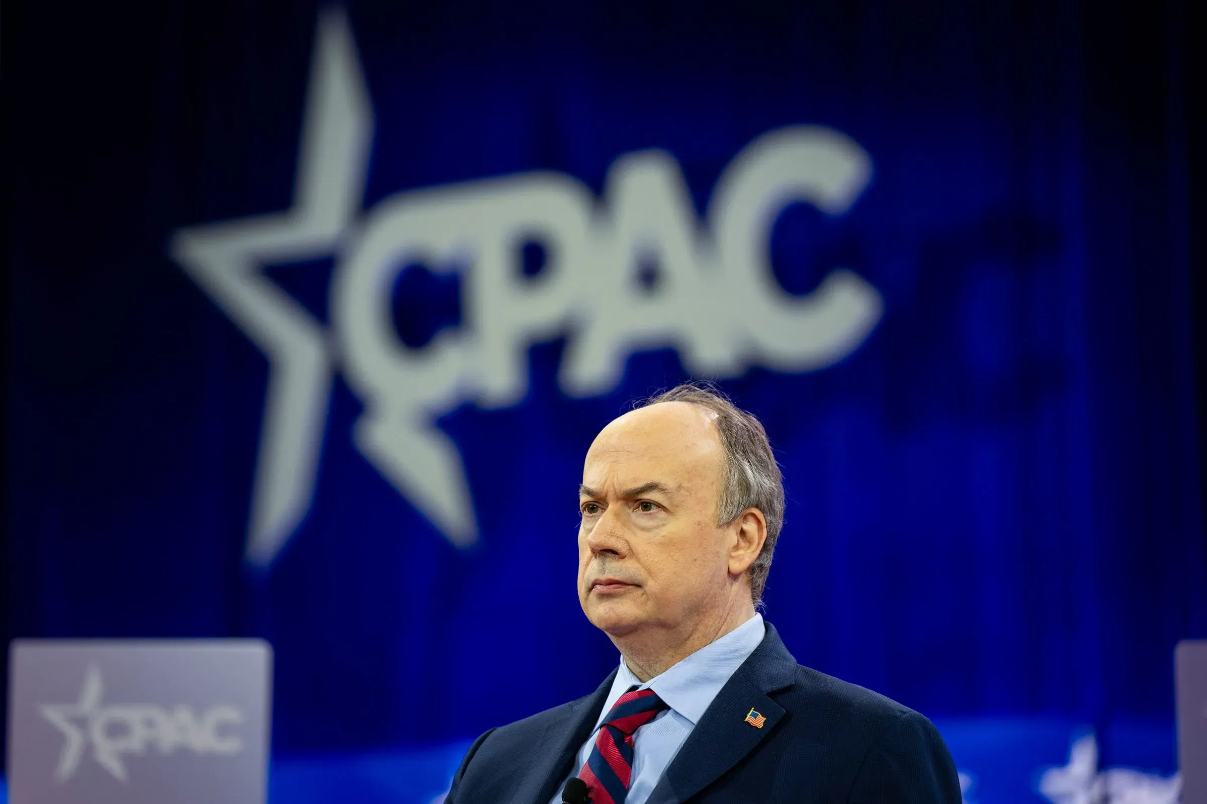 جيفري كلارك، محامٍ سابق، يقف أمام شعار مؤتمر العمل السياسي المحافظ (CPAC) خلال مناقشات حول محاولاته لتعطيل نتائج انتخابات 2020.