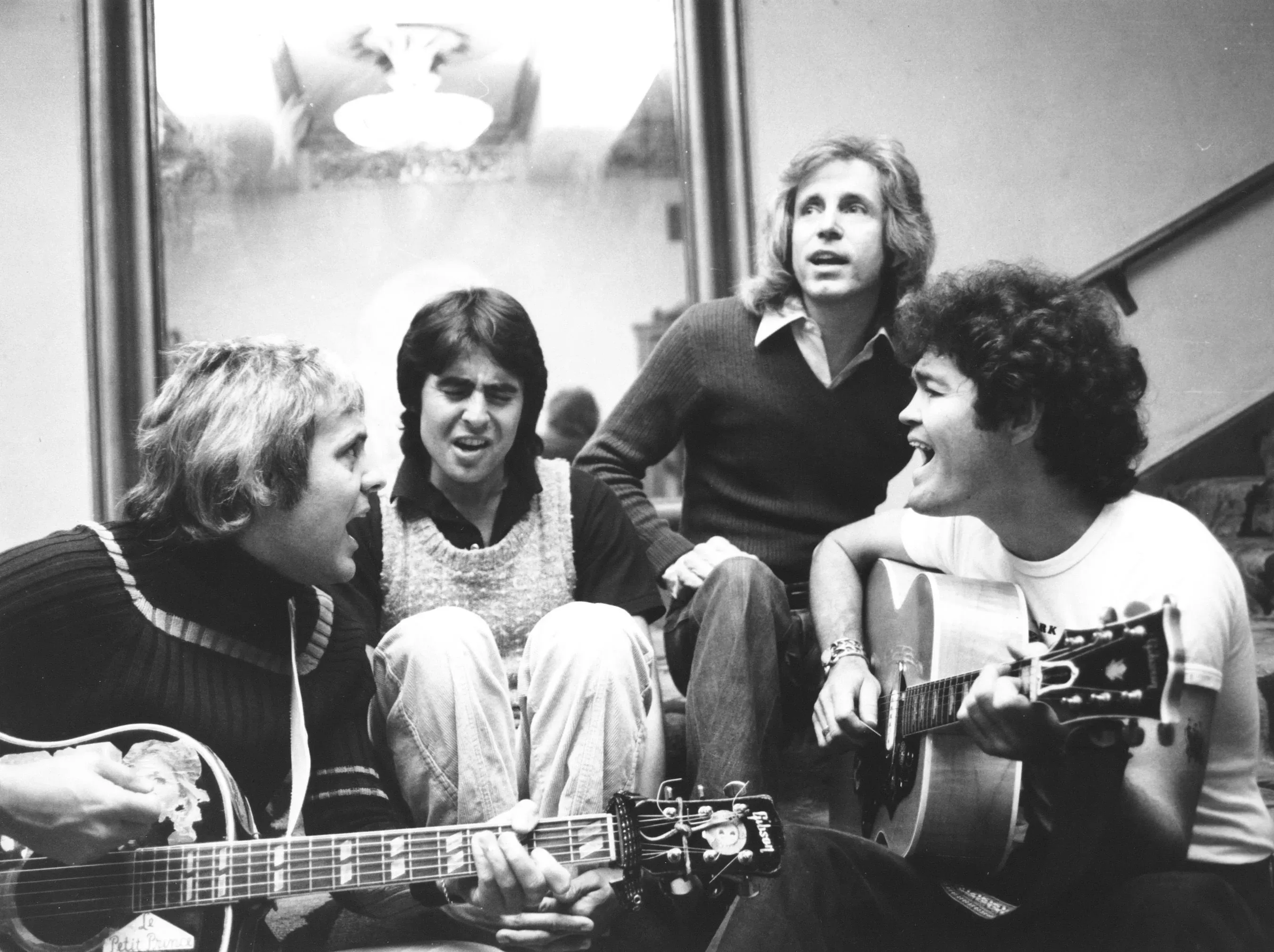 تجمع الصورة أعضاء فرقة مونكيز، بوبي هارت وتومي بويس، في جلسة موسيقية، مع التركيز على تفاعلهم الإبداعي وأدواتهم الموسيقية.