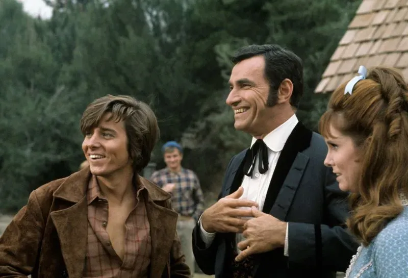 بوبي شيرمان، نجم السبعينيات، مبتسمًا مع زملائه في موقع تصوير، يظهر تأثيره في عالم الموسيقى والتلفزيون.