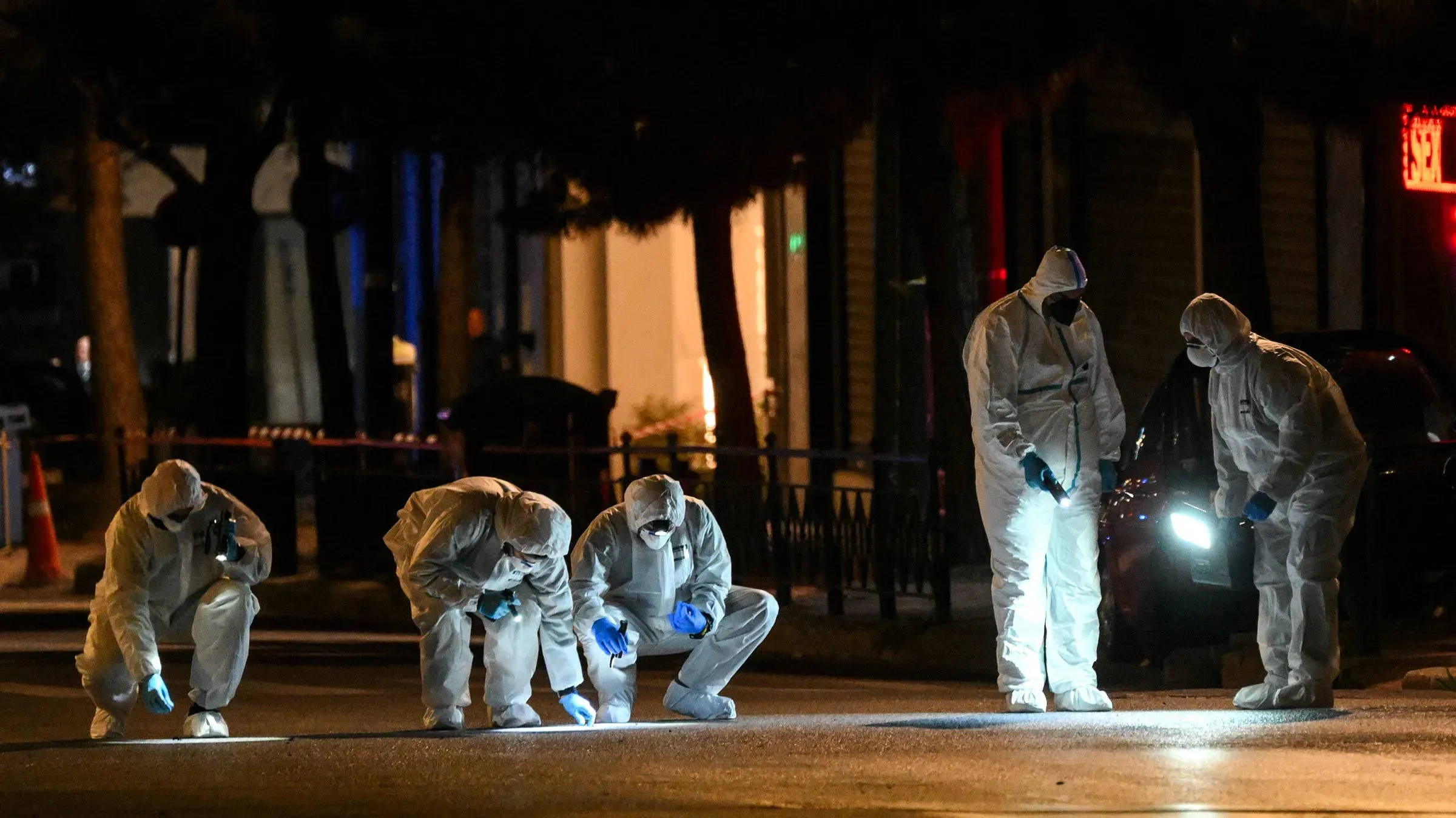 فريق من المحققين يرتدي ملابس واقية يجري فحصًا في موقع انفجار قرب مكاتب شركة هيلينيك ترين في أثينا، بعد تلقي تحذيرات عن قنبلة.