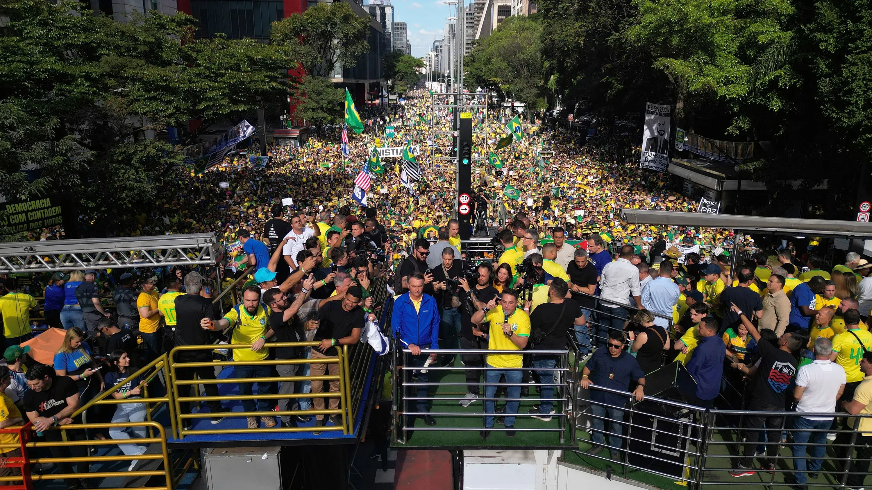 تجمع حشود كبيرة في ساو باولو احتجاجًا على محاكمة جايير بولسونارو، مع لافتات وأعلام تعبر عن مطالب للحرية والعدالة.