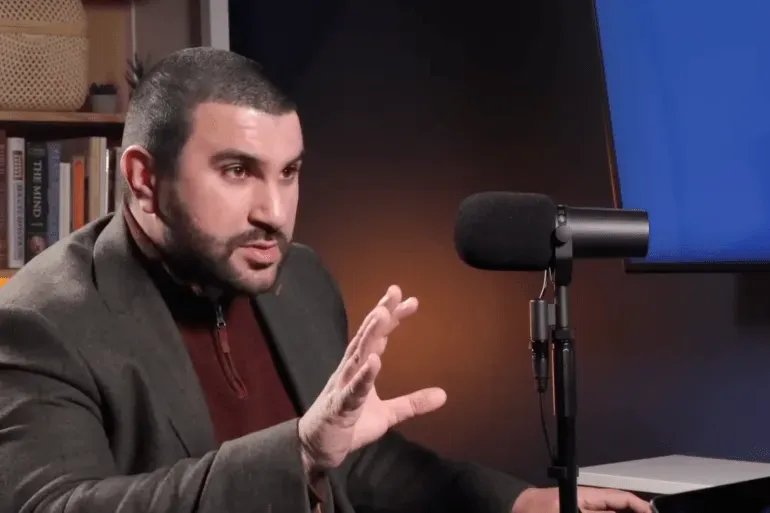 سامي حمدي، المعلق والصحفي، يتحدث بجدية في برنامج حواري، مع التركيز على قضايا حقوق الفلسطينيين.