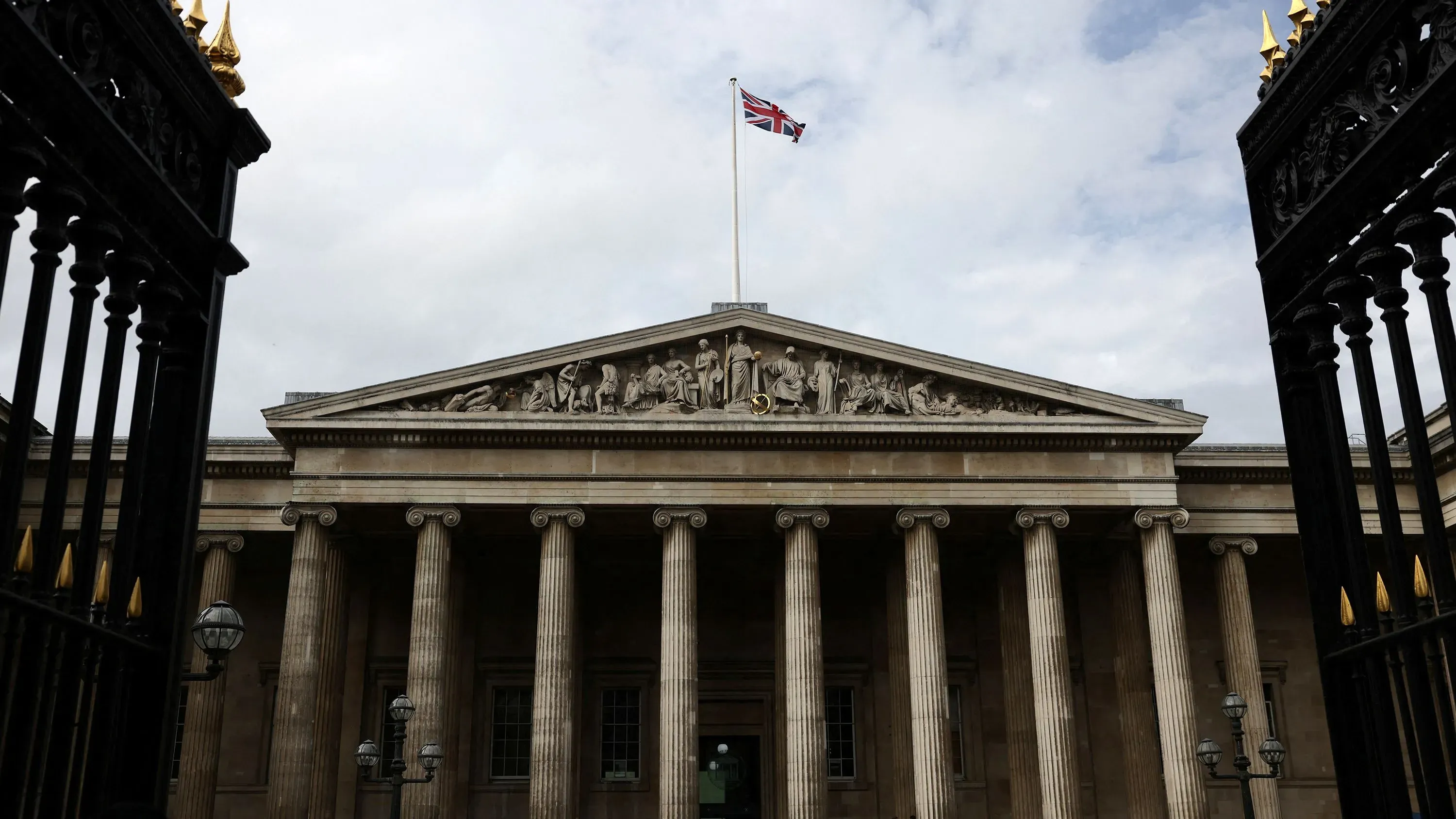 مبنى المتحف البريطاني في وسط لندن، يحمل العلم البريطاني فوقه، مع أبواب مغلقة نتيجة إغلاق جزئي بسبب اعتداء تكنولوجي.