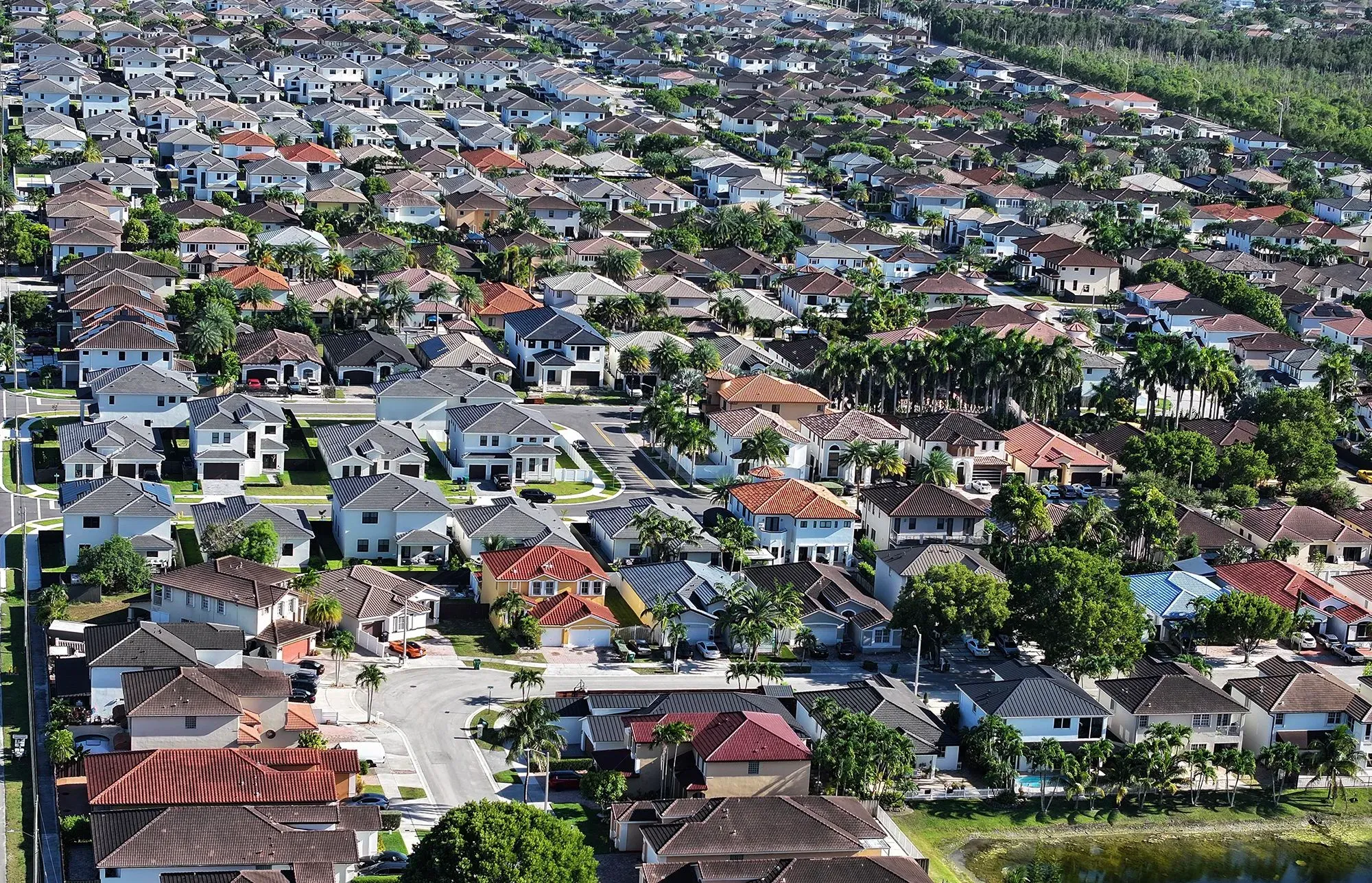 مشهد جوي لحي سكني في فلوريدا يظهر مجموعة من المنازل الحديثة، مع أشجار ونباتات تحيط بها، مما يعكس تغيرات سوق الإسكان.