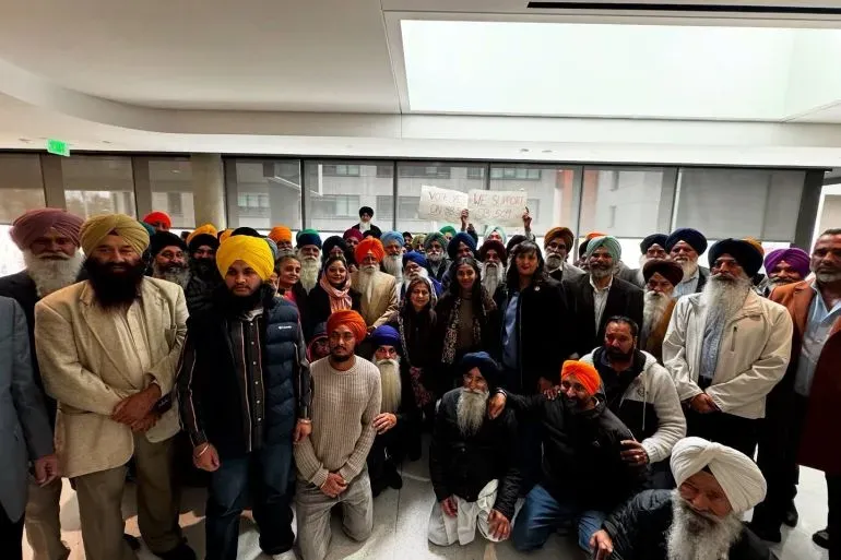 مجموعة من الأمريكيين السيخ في مبنى الكابيتول بولاية كاليفورنيا، يدعمون مشروع قانون لمكافحة الترهيب، مع لافتة تعبر عن تأييدهم.