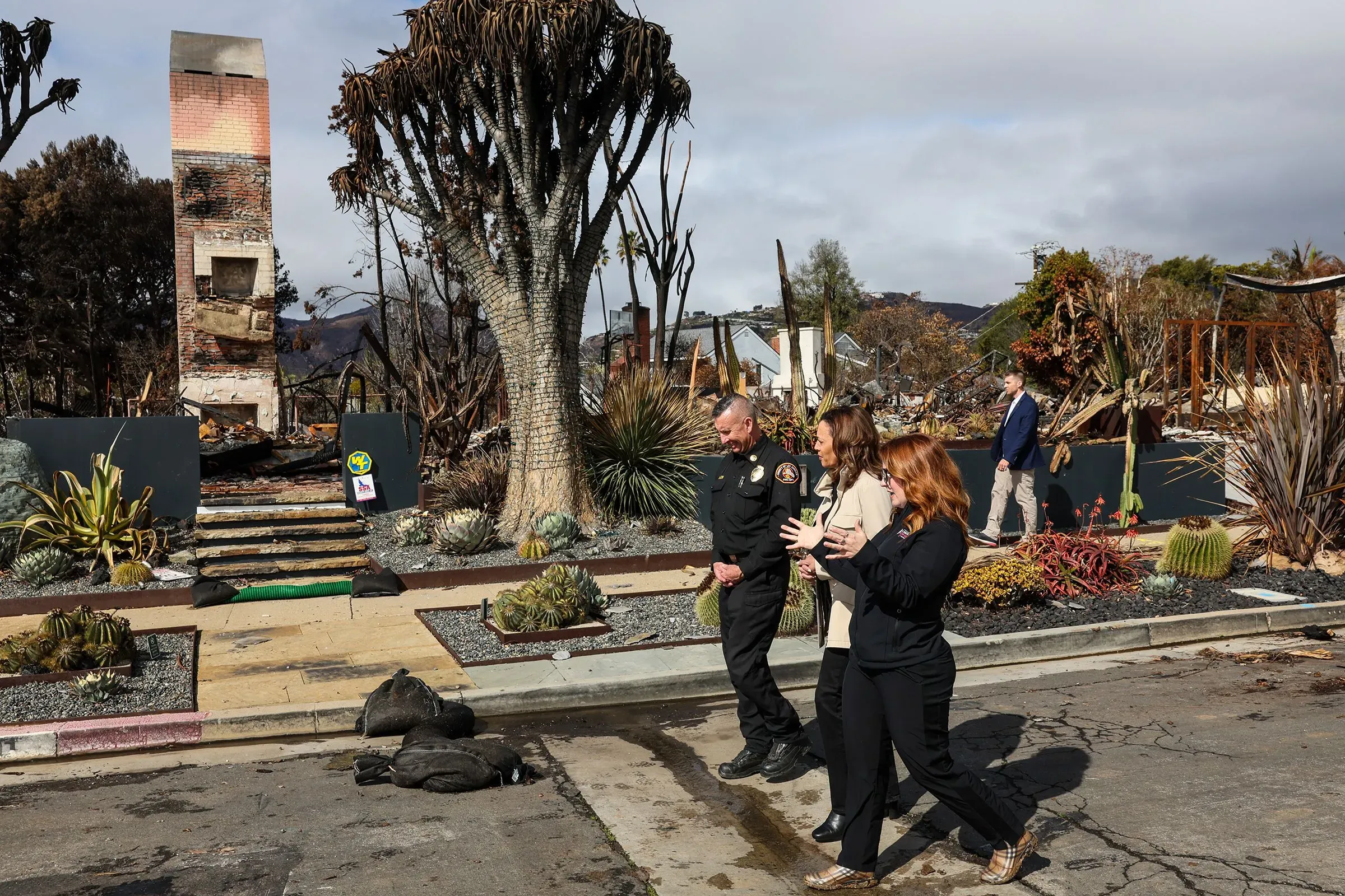 زيارة نائب الرئيس كامالا هاريس لموقع حريق مدمر في كاليفورنيا، حيث تتحدث مع مسؤولين محليين وسط الدمار.