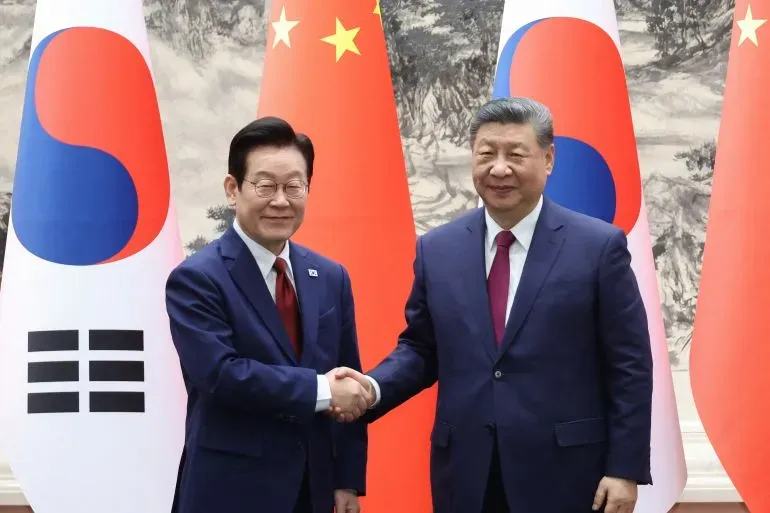 رئيسا الصين وكوريا الجنوبية يتصافحان خلال قمة لتعزيز العلاقات الثنائية، وسط توترات إقليمية متزايدة.