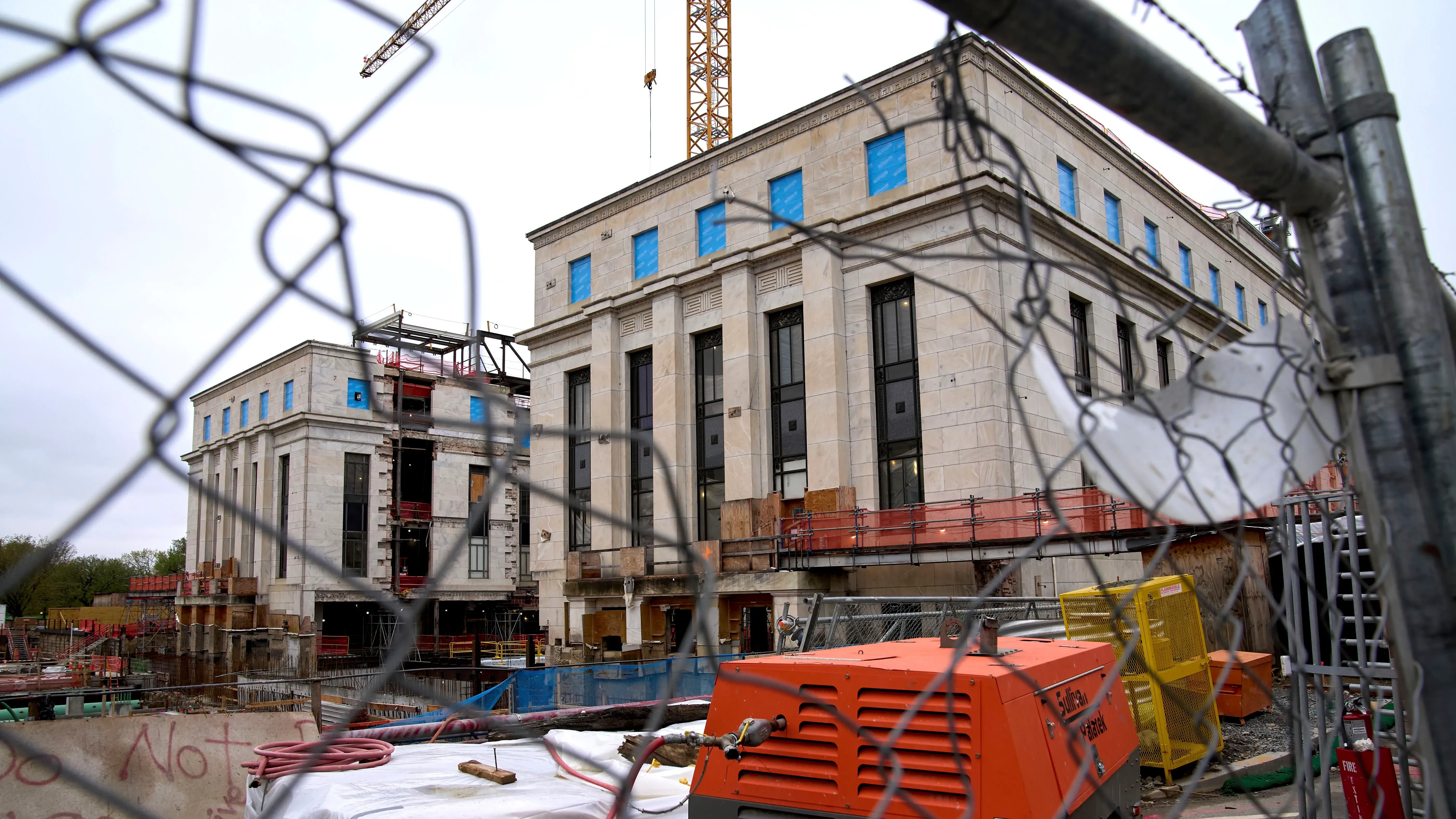 تجديد مبنى الاحتياطي الفيدرالي في واشنطن، يظهر البناء مع سياج وأدوات تشييد، مما يعكس تجاوز التكاليف والمشاكل المرتبطة بالمشروع.