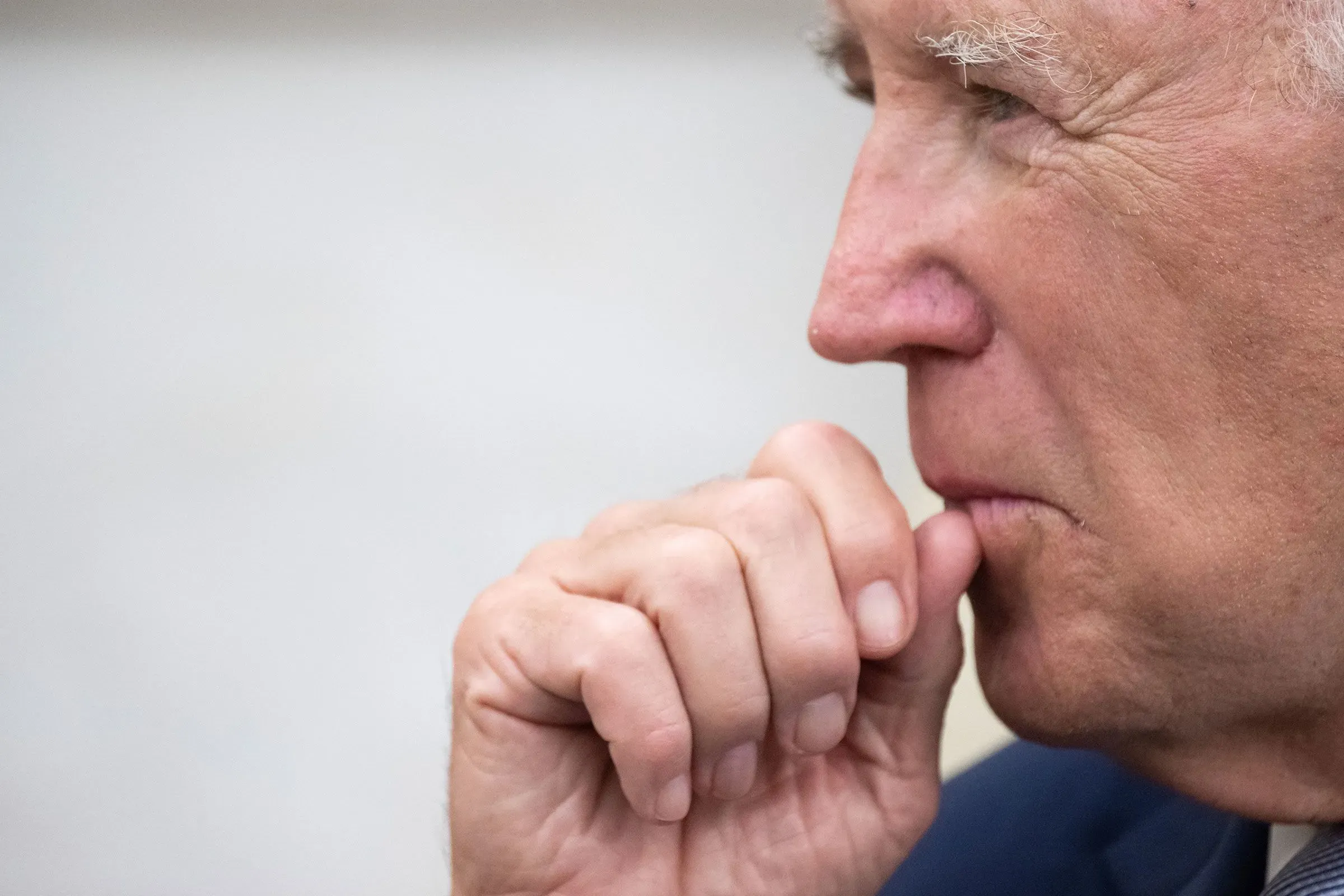 صورة تُظهر جانب وجه الرئيس بايدن وهو يضع إصبعه على شفتيه، مما يعكس تفكيرًا عميقًا حول قرارات العفو المثيرة للجدل.