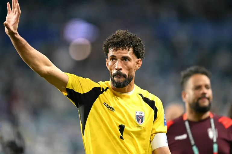 حارس مرمى منتخب كابو فيردي يلوح بيده للجماهير خلال مباراة كأس العالم، مع التركيز على فخر وتألق الفريق في البطولة.