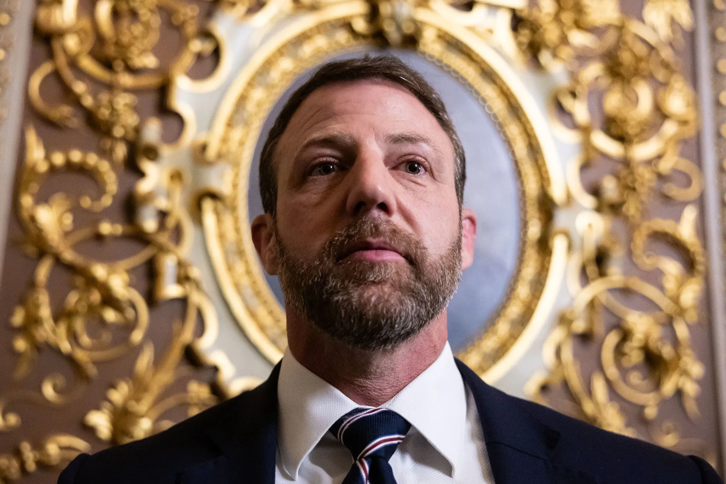 ماركواين مولين، وزير الأمن الداخلي الجديد، يتحدث خلال جلسة استماع في مجلس الشيوخ، مع خلفية مزخرفة تعكس أهمية منصبه.