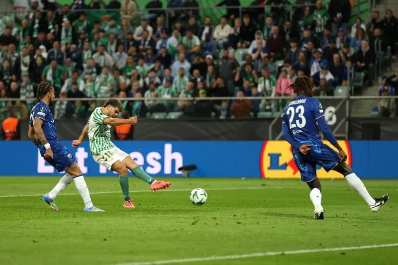 لاعب ريال بيتيس عبدة الزلزولي يسدد كرة نحو مرمى تشيلسي، مع وجود مدافعين من الفريق الإنجليزي في الخلف.