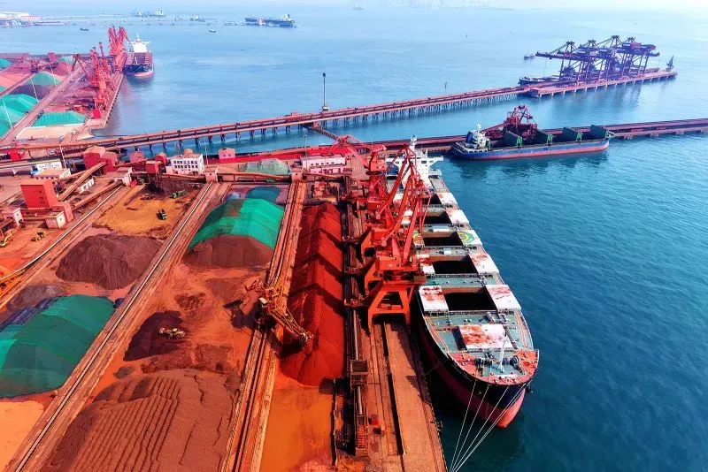 صورة تظهر ميناءً بحريًا في الصين حيث تُخزن المعادن الأرضية النادرة، مع سفن شحن جاهزة لنقل الشحنات. تعكس الصورة أهمية الصين في سوق المعادن العالمية.