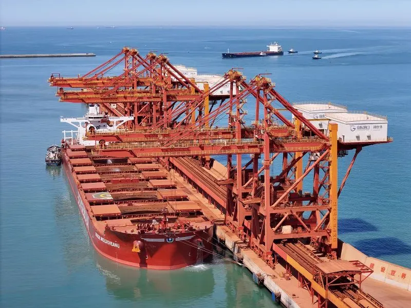 صورة تظهر سفينة شحن كبيرة محملة بالمعادن في ميناء، تعكس التوترات التجارية بين الصين والولايات المتحدة وتأثيرها على صادرات المعادن.