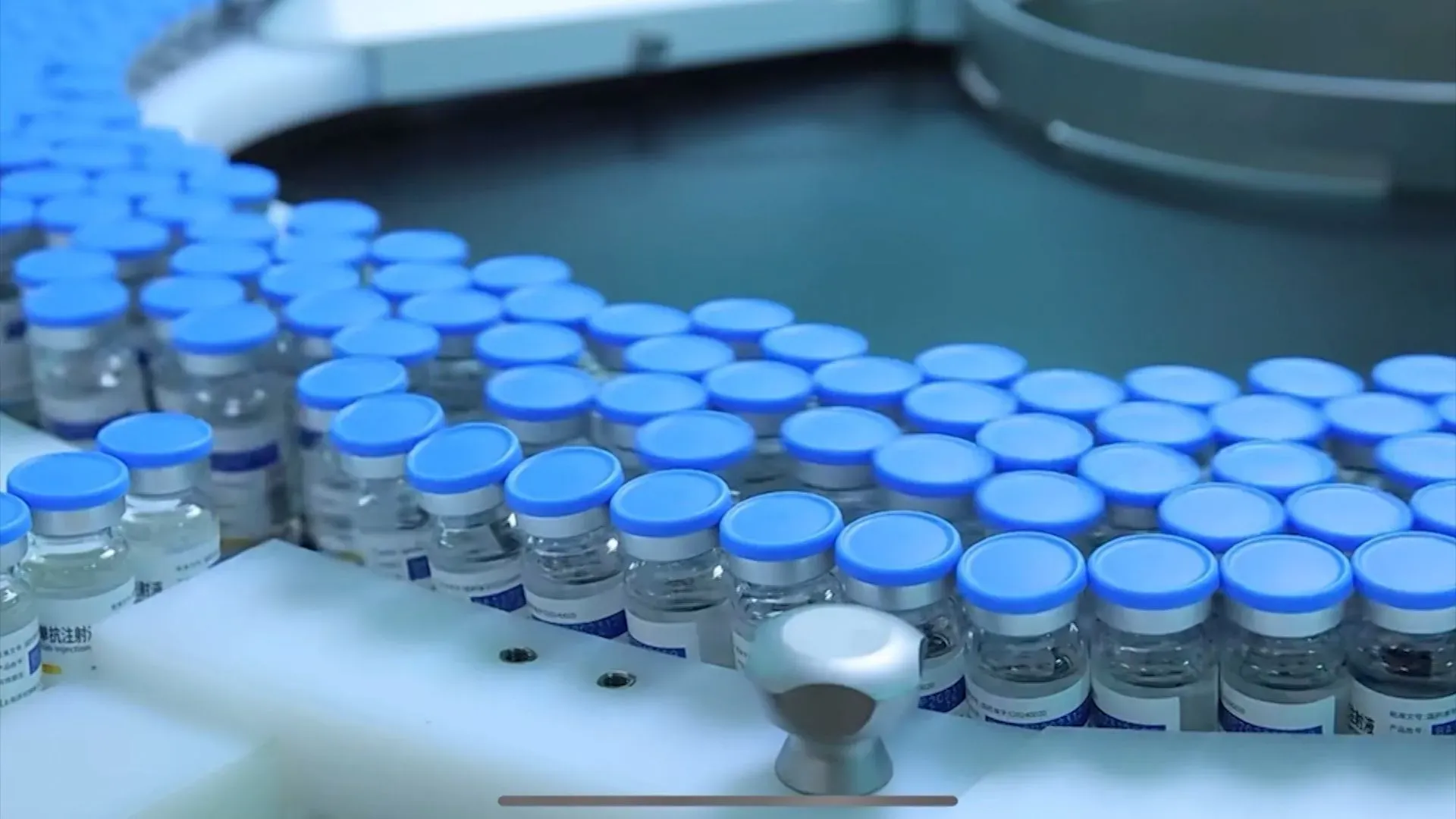 زجاجات أدوية مرتبة بشكل منظم على حزام ناقل، تمثل الابتكار في صناعة الأدوية الصينية، مع التركيز على عقار Ivonescimab لعلاج سرطان الرئة.