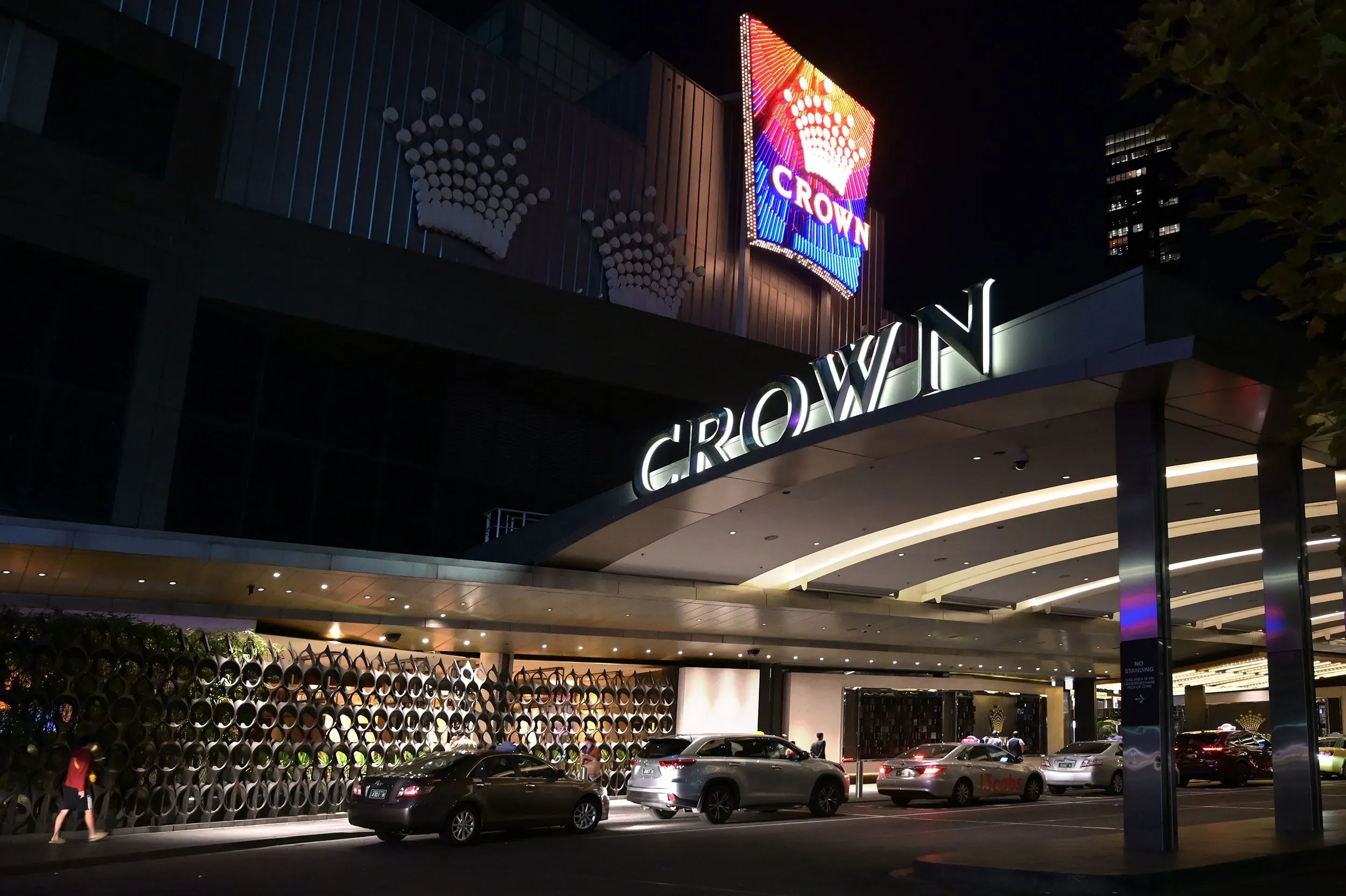 مدخل كازينو "كراون" في لاس فيغاس مضاء بأضواء ملونة، مع سيارات متوقفة أمامه، مما يعكس أجواء الحياة الليلية الصاخبة.