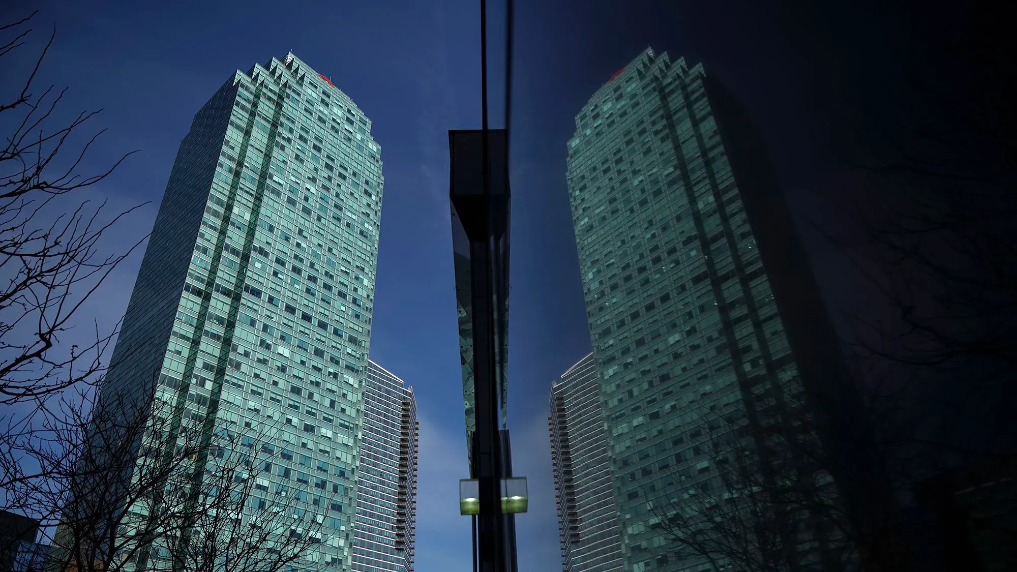 صورة لبرج سيتي جروب الزجاجي في مدينة نيويورك، يعكس سماء زرقاء وصورة مباني مجاورة، مما يبرز التغييرات في سياسات البنك.