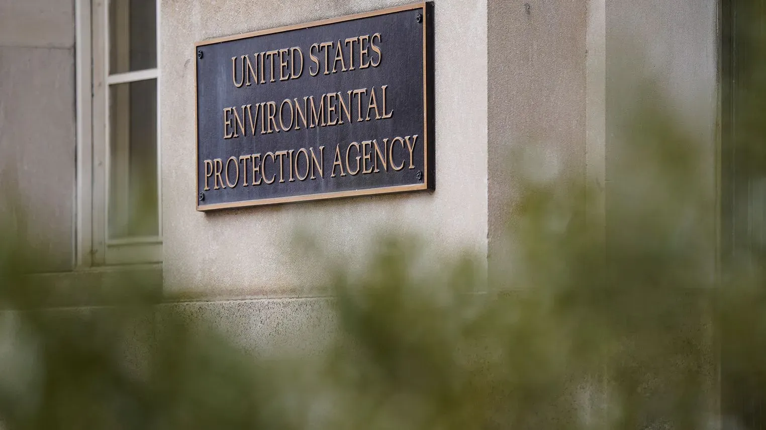 علامة وكالة حماية البيئة الأمريكية مثبتة على مبنى، تعكس الجدل حول تمويل مشاريع الطاقة النظيفة وتجميد المنح الفيدرالية.